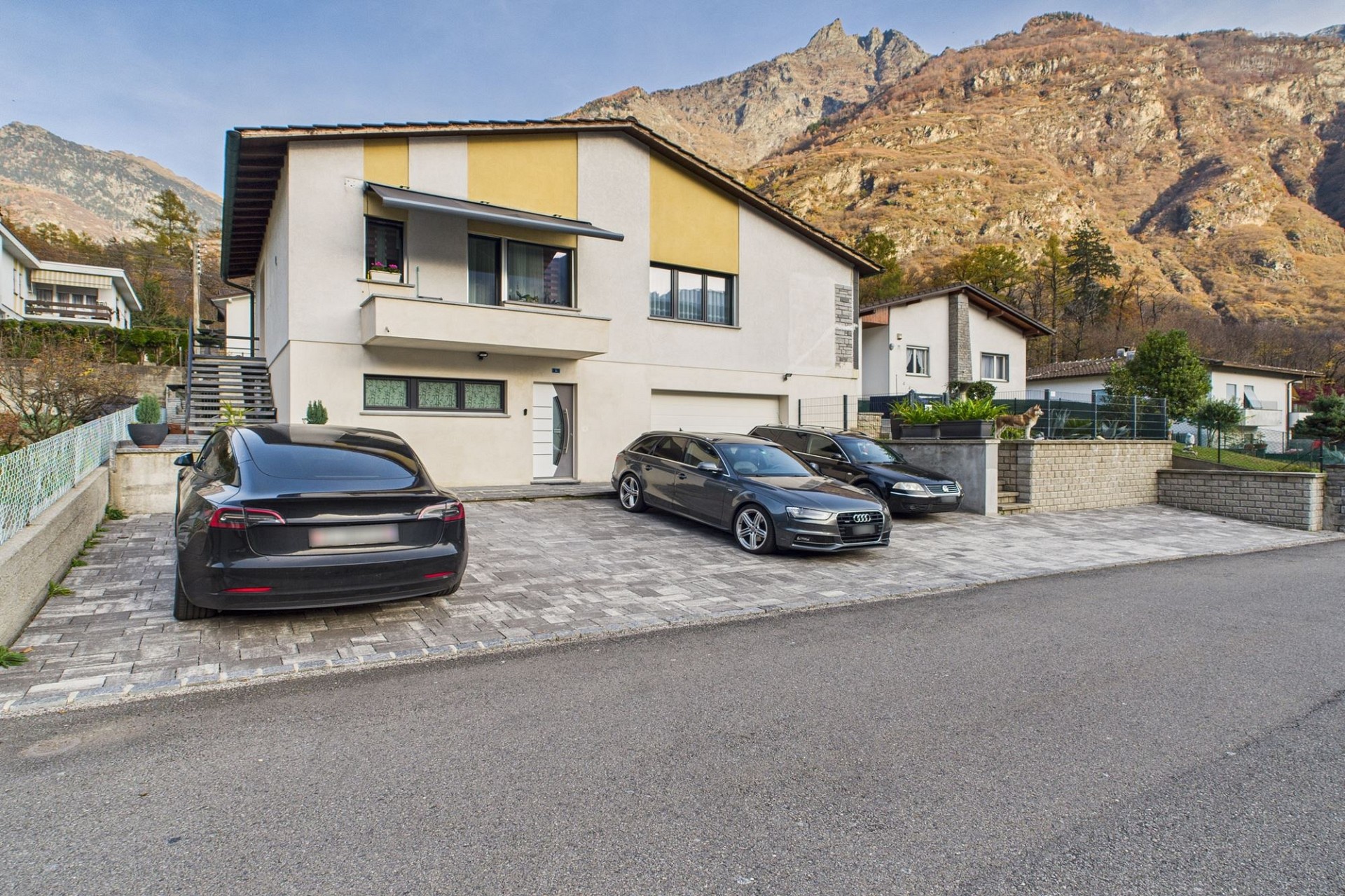 Modernes Einfamilienhaus mit Bergkulisse und großer Zufahrt