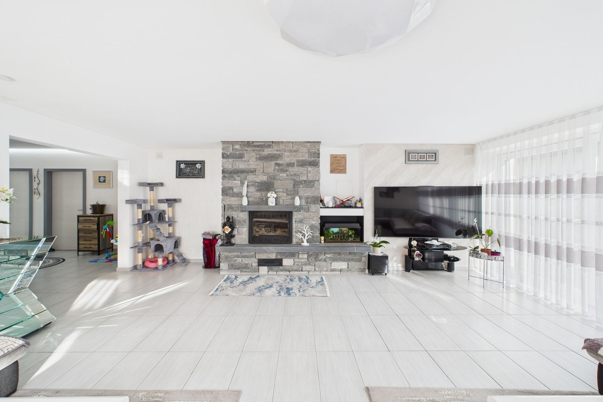 Helles Wohnzimmer mit Kamin und TV-Wand