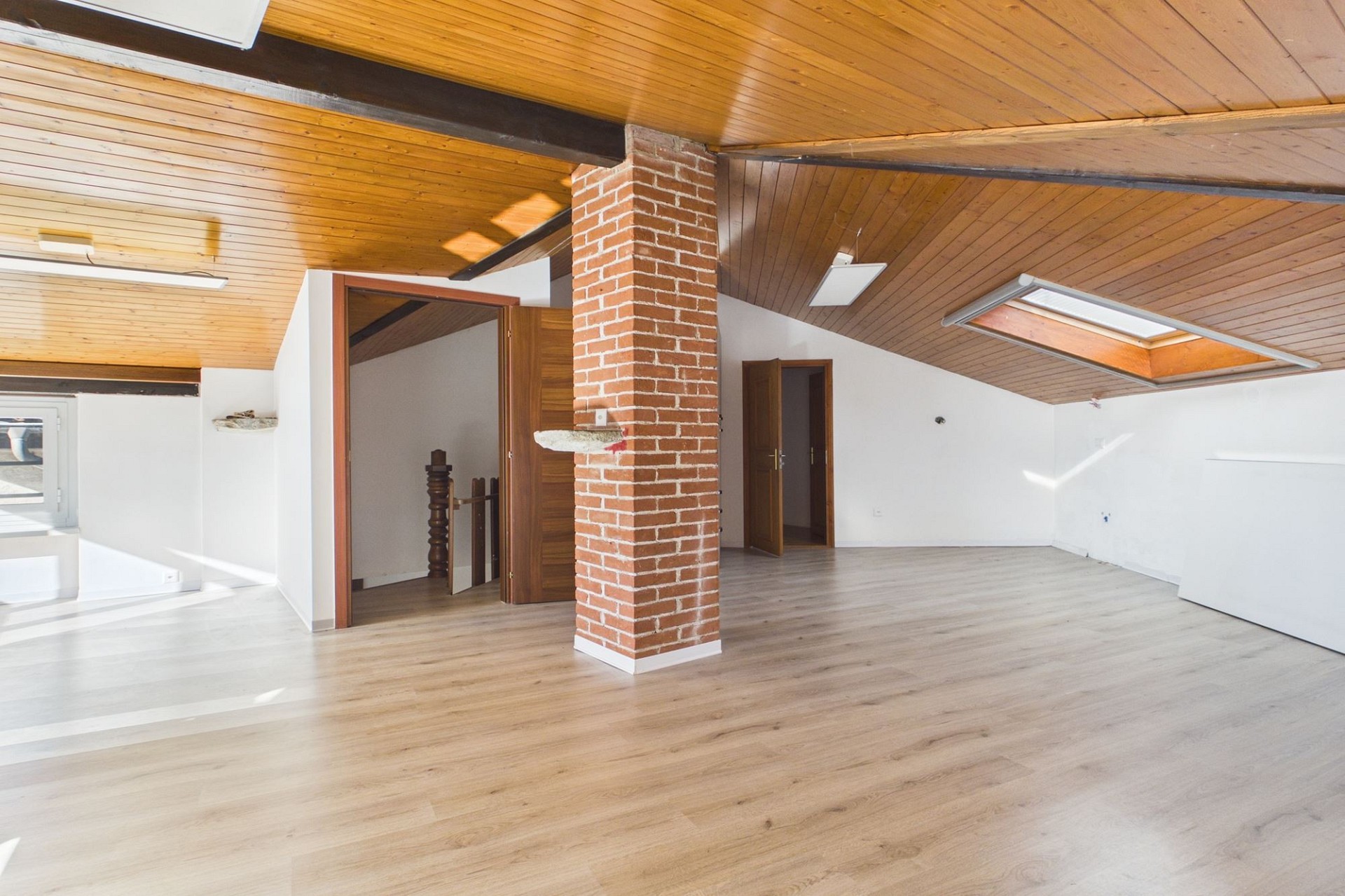 Ausgebauter Dachraum mit Holzbalken und Ziegelstütze