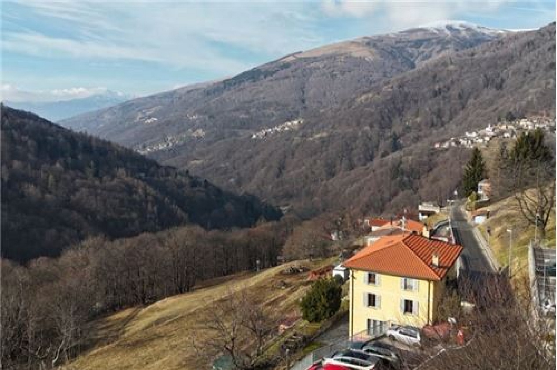 Bergblick über ein Tal mit Haus am Hang