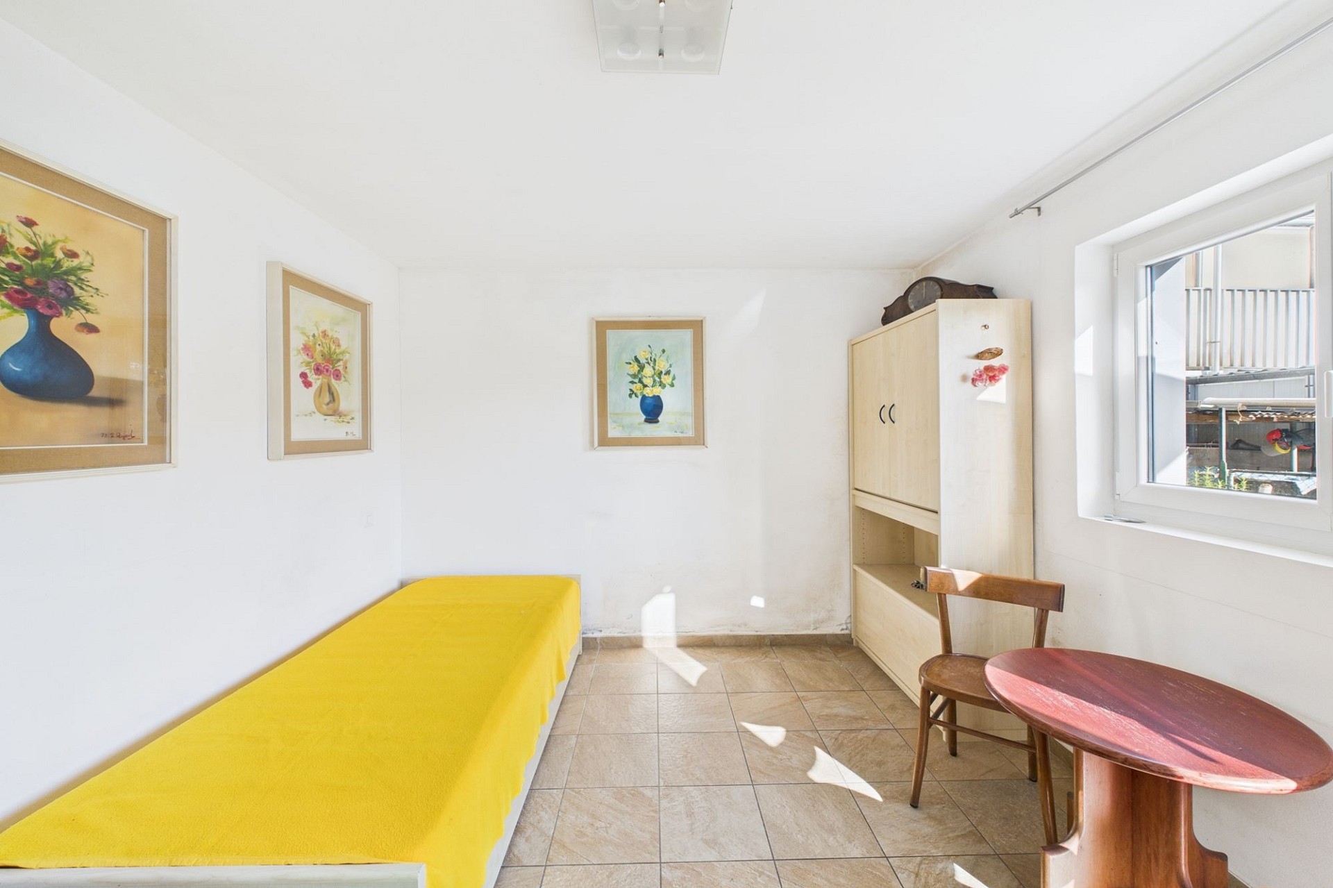 Helles kleines Zimmer mit Bett, Schrank und Fenster
