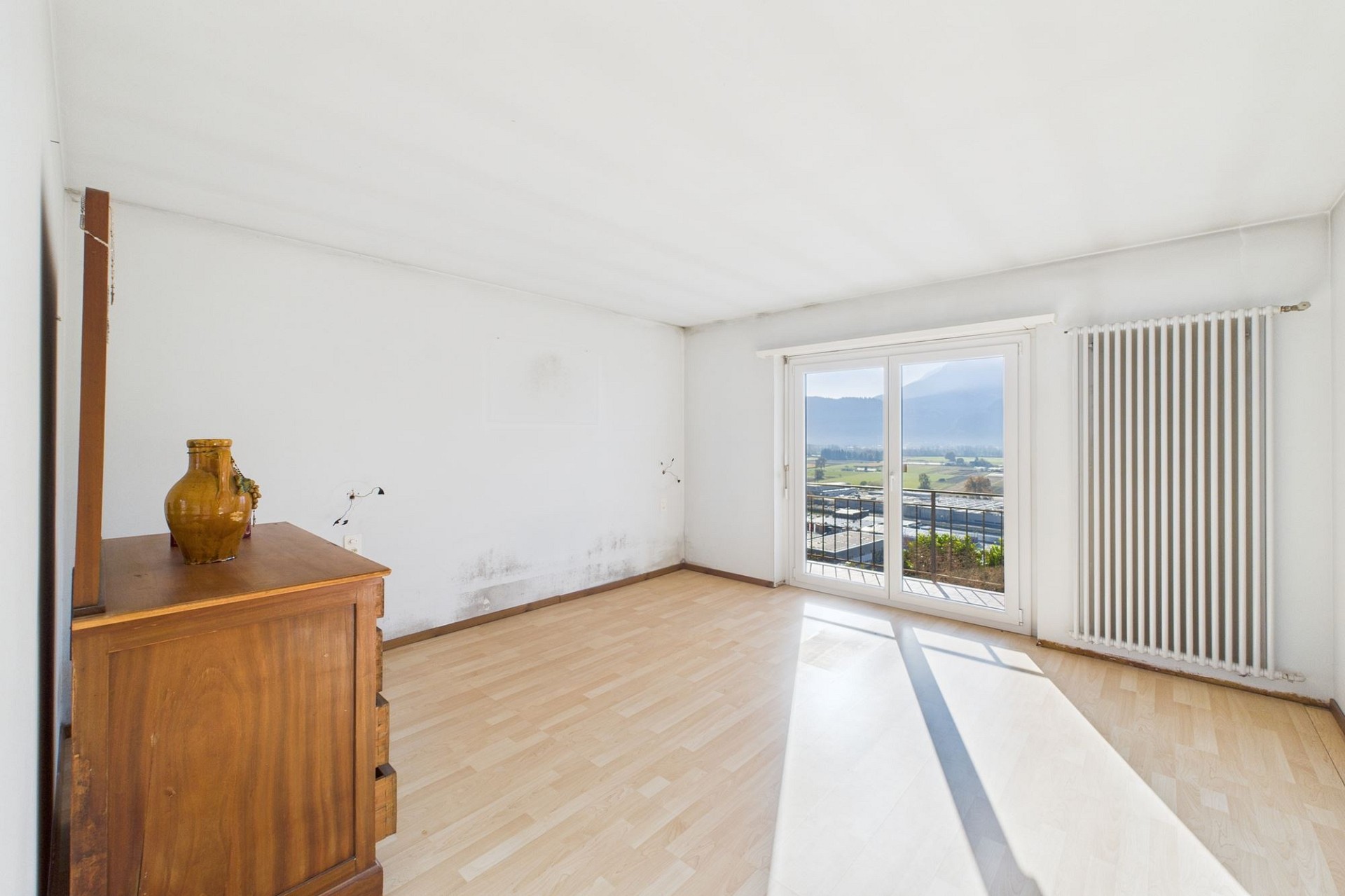 Helles, leerstehendes Zimmer mit Balkonblick