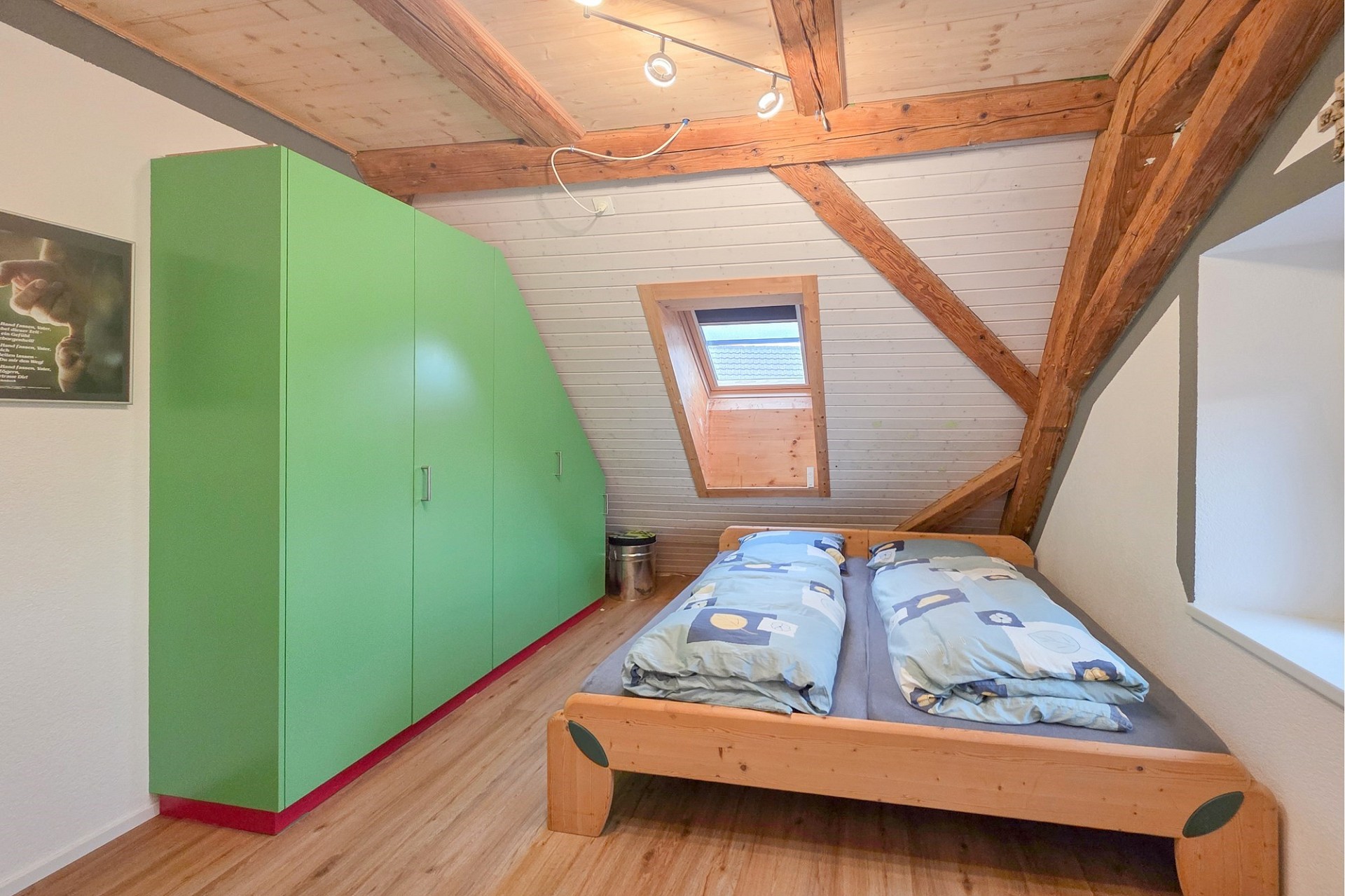 Dachzimmer mit Bett und Einbauschrank