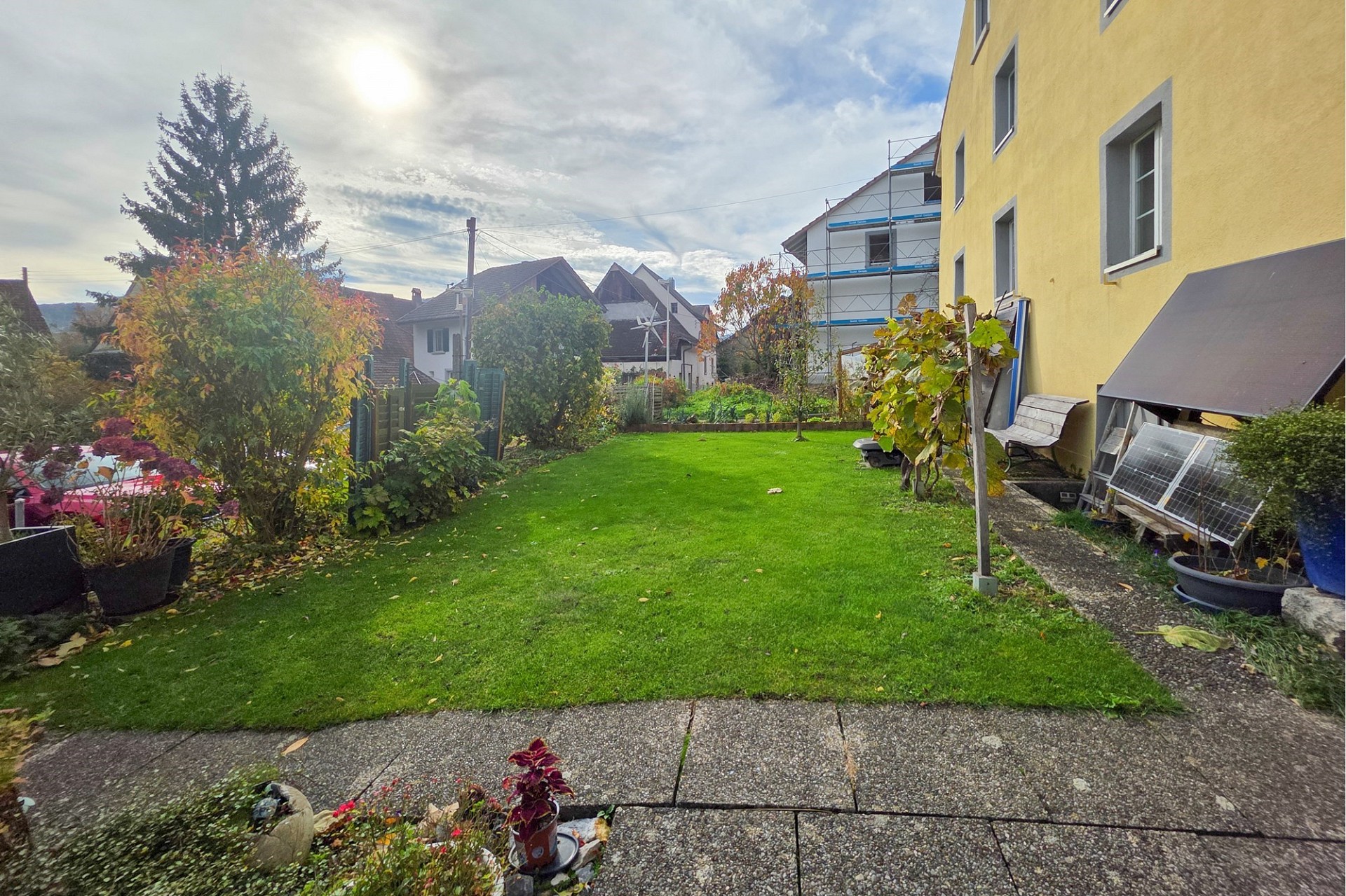 Garten mit Wohnhaus und Nachbarbebauung