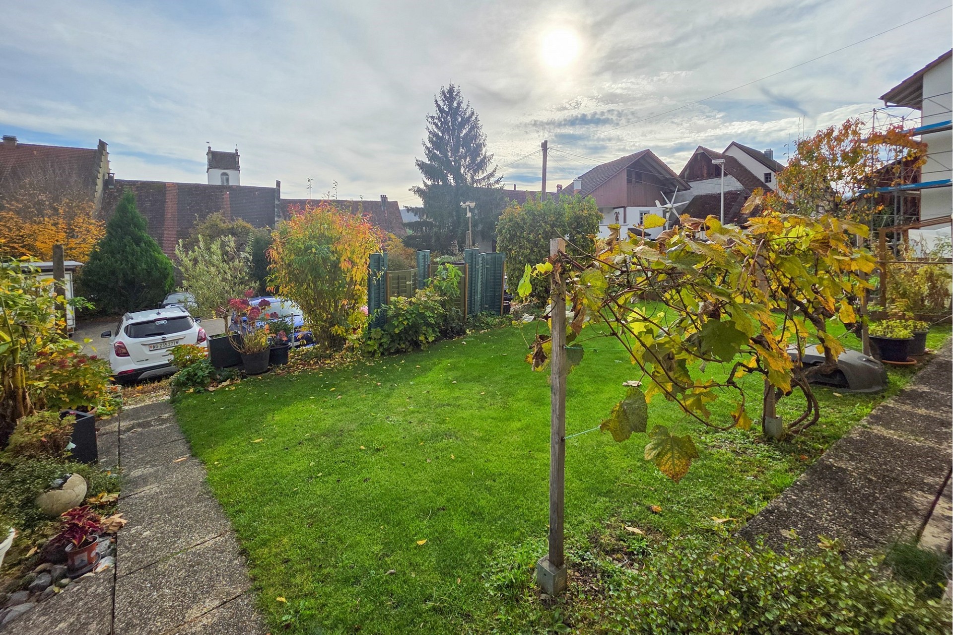 Großer Garten mit Rasen und Nachbarbebauung