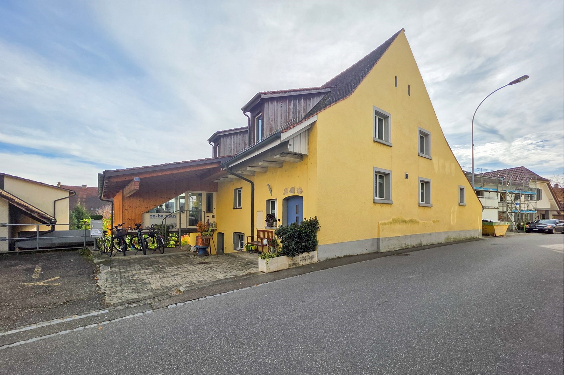 Gelbes Wohnhaus mit steilem Giebel und Anbau