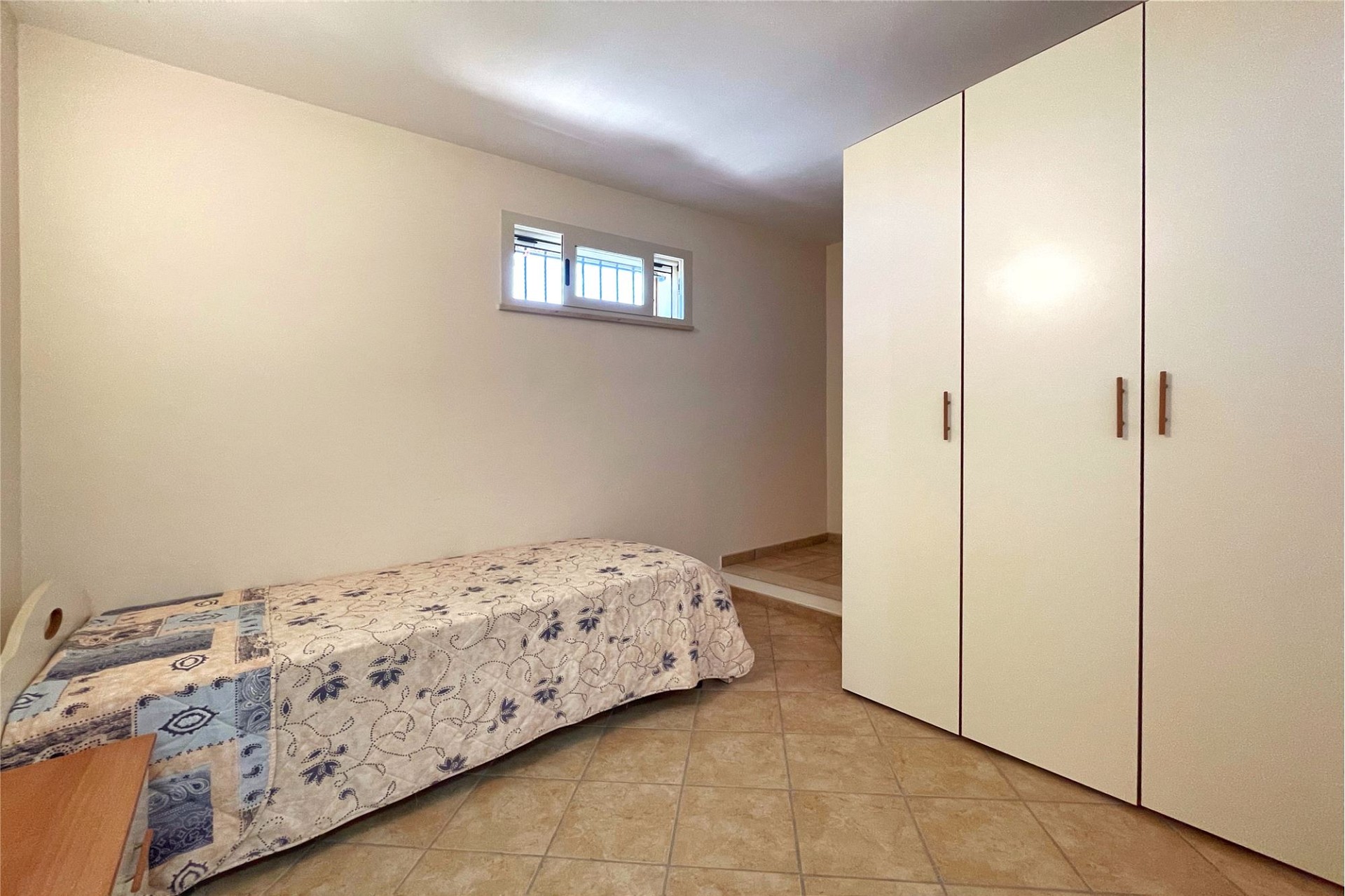 Kleines Schlafzimmer mit Bett und Schrank