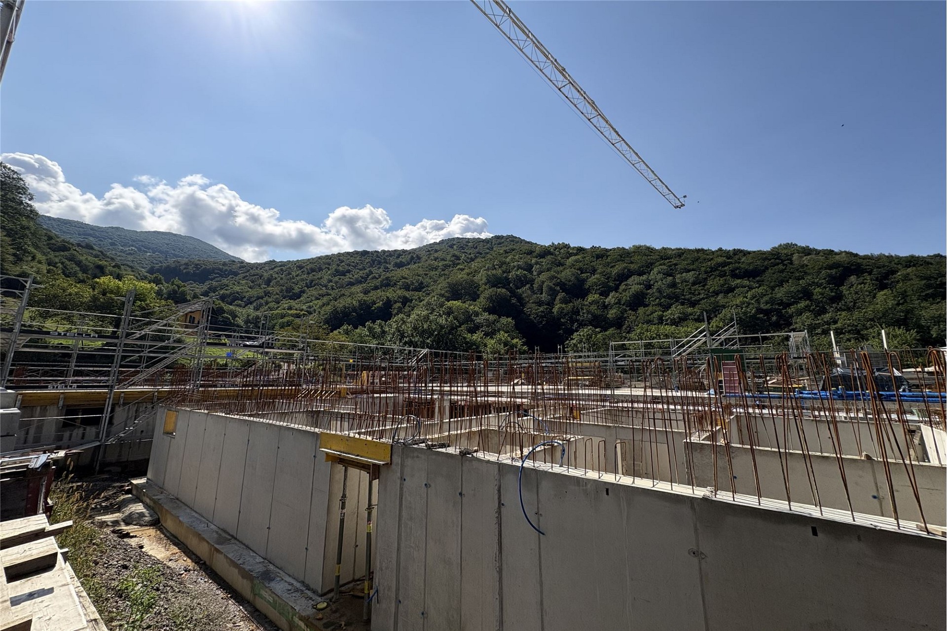 Baustelle mit Betonstruktur und Bergkulisse