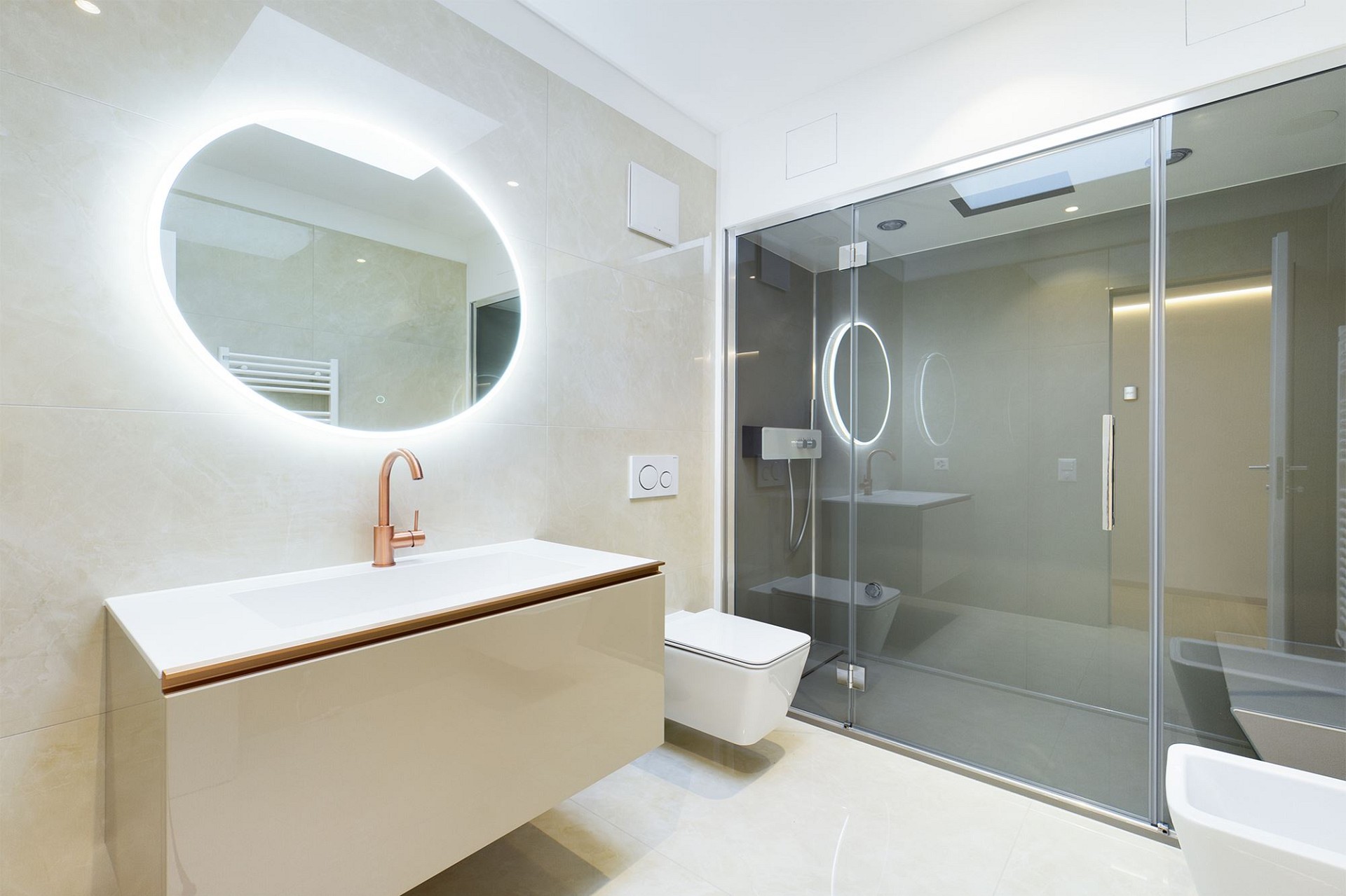 Modernes Badezimmer mit Glasdusche und beleuchtetem Spiegel