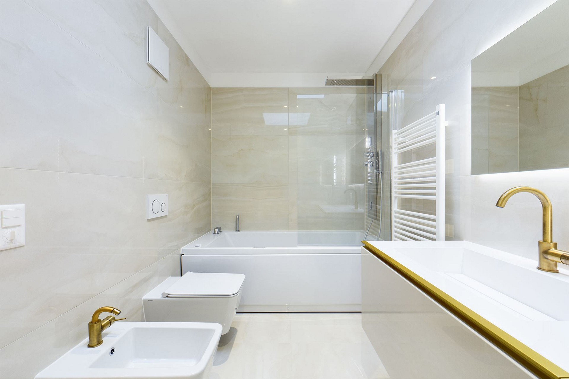 Modernes Badezimmer mit Badewanne und goldener Armatur