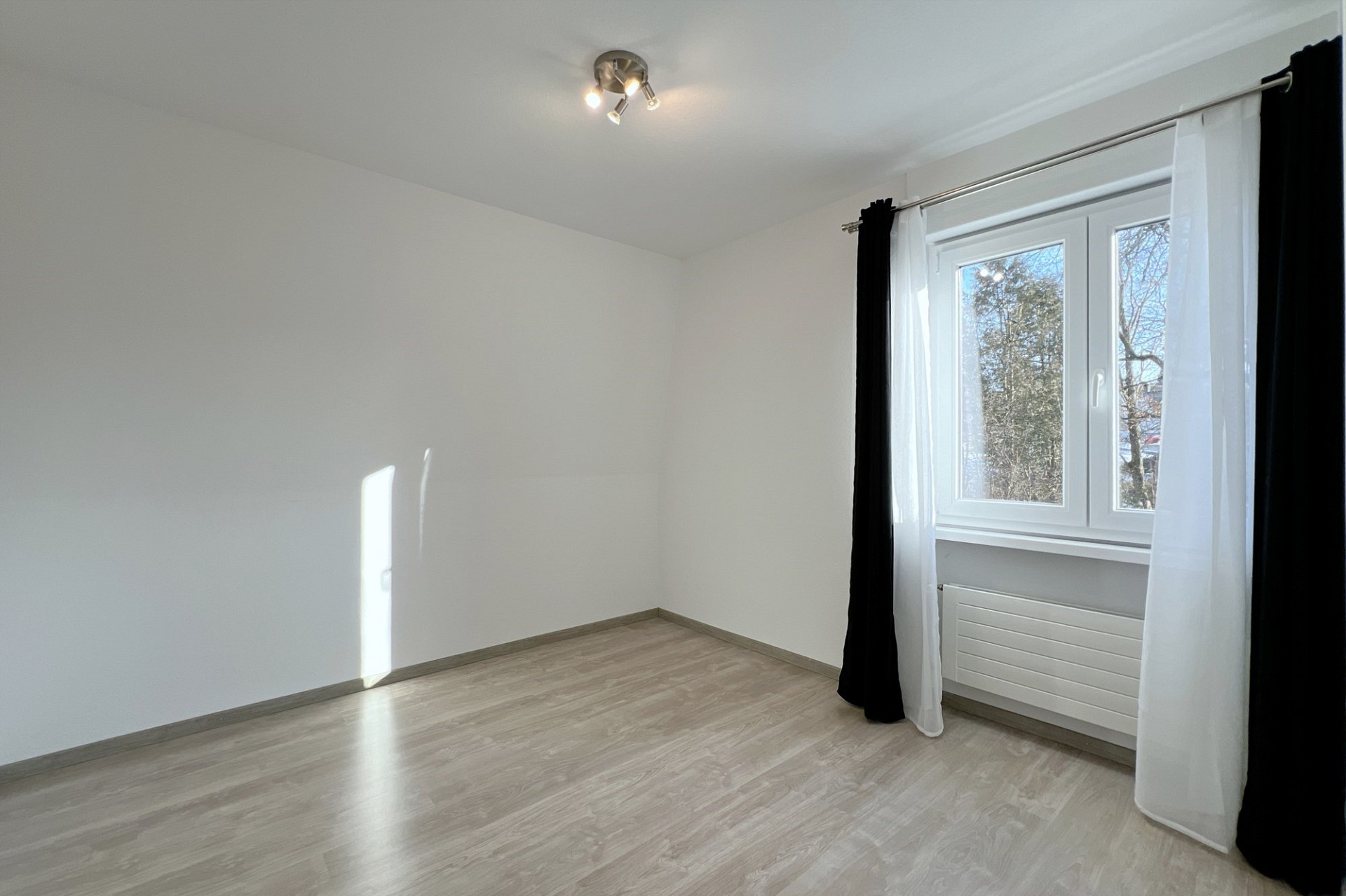 Helles, leeres Zimmer mit Fenster