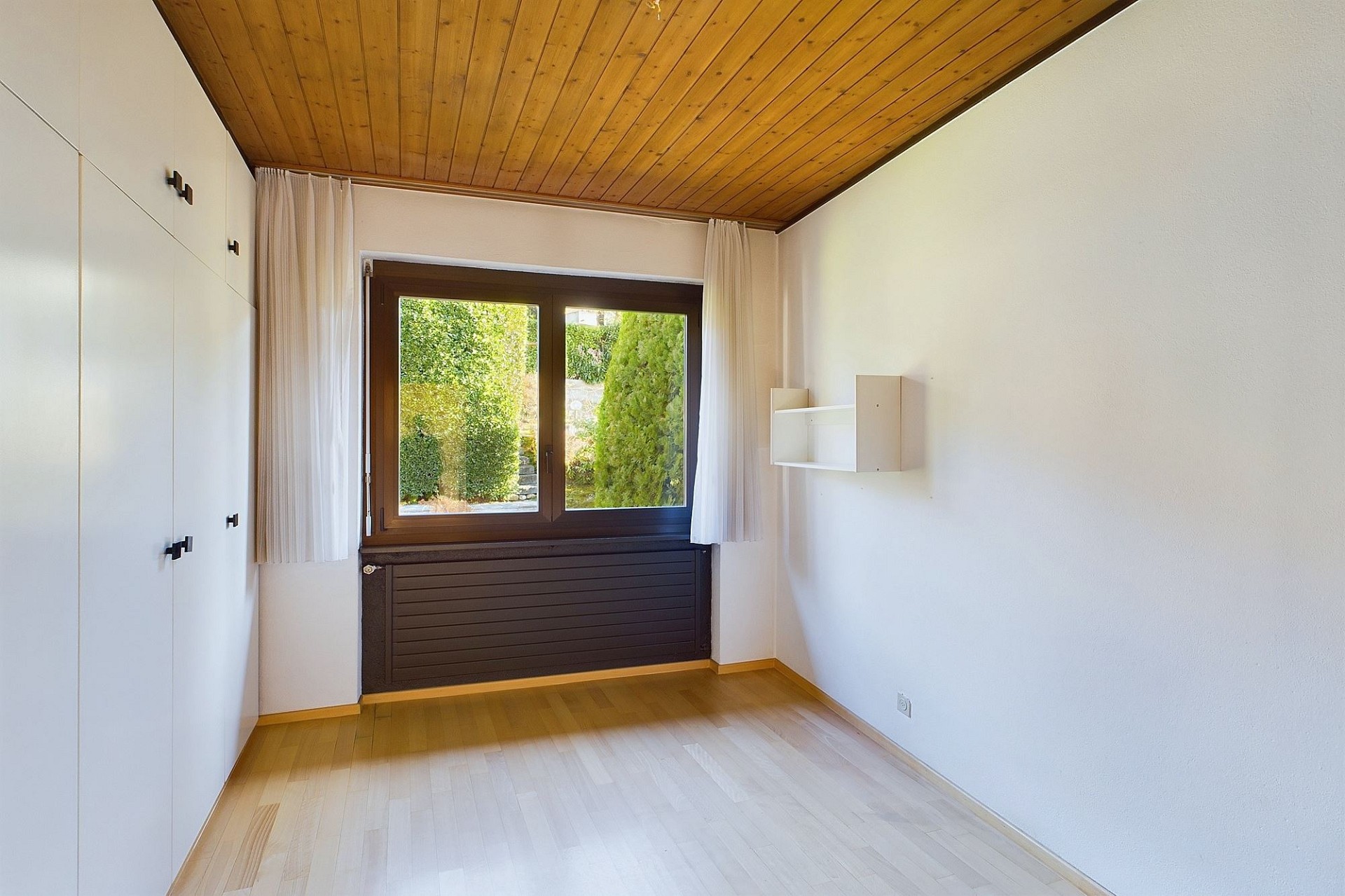 Helles Zimmer mit Holzdecke und Einbauschrank