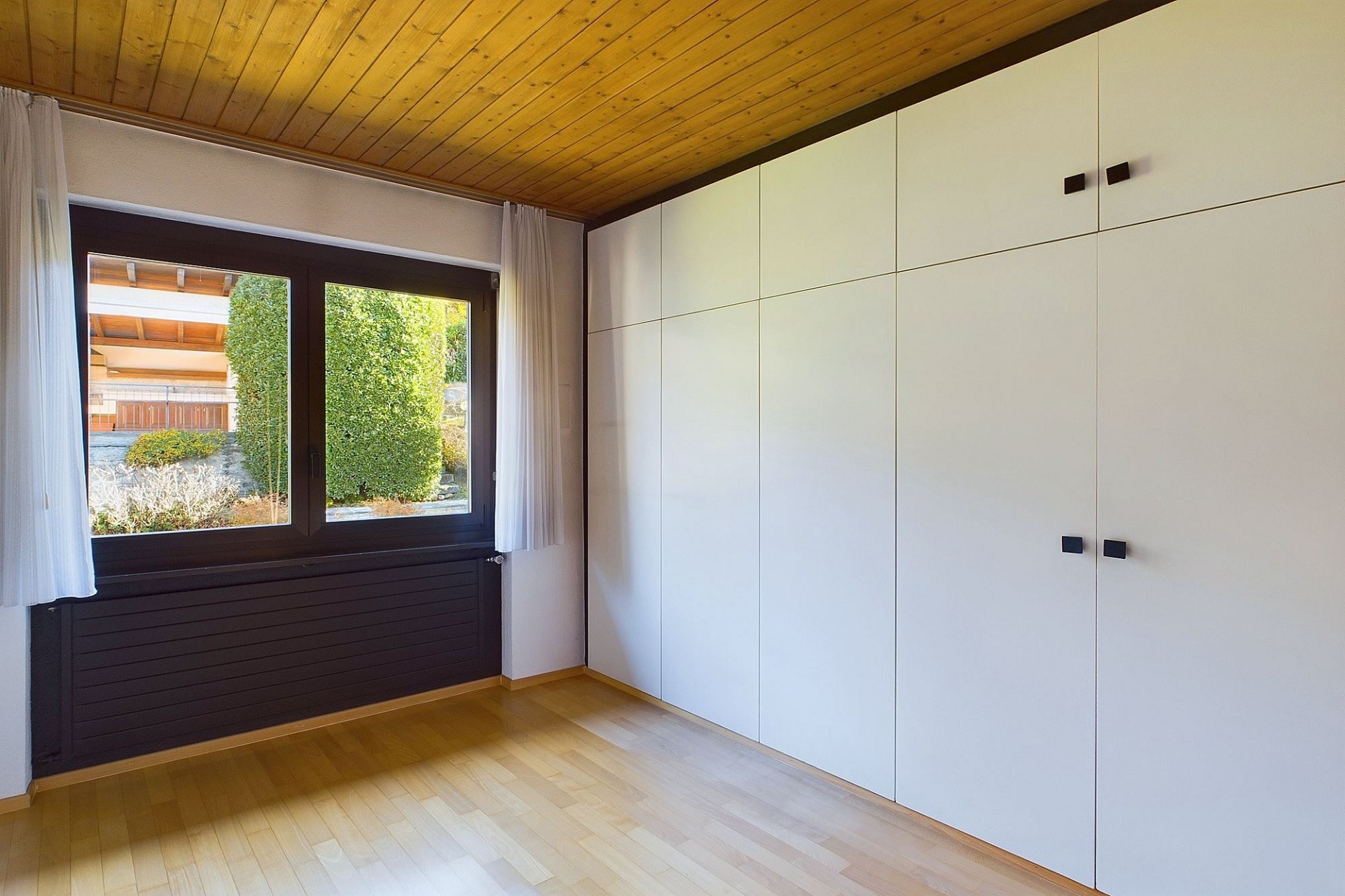 Helles Zimmer mit Einbauschrank und Holzdecke
