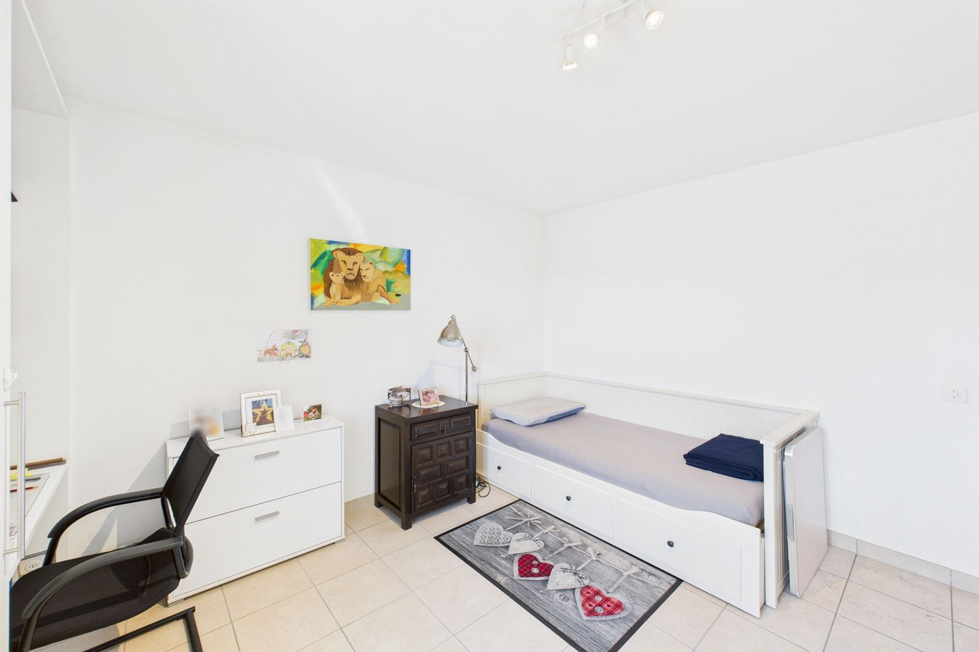 Helles Schlafzimmer mit Einzelbett und Schreibtischecke