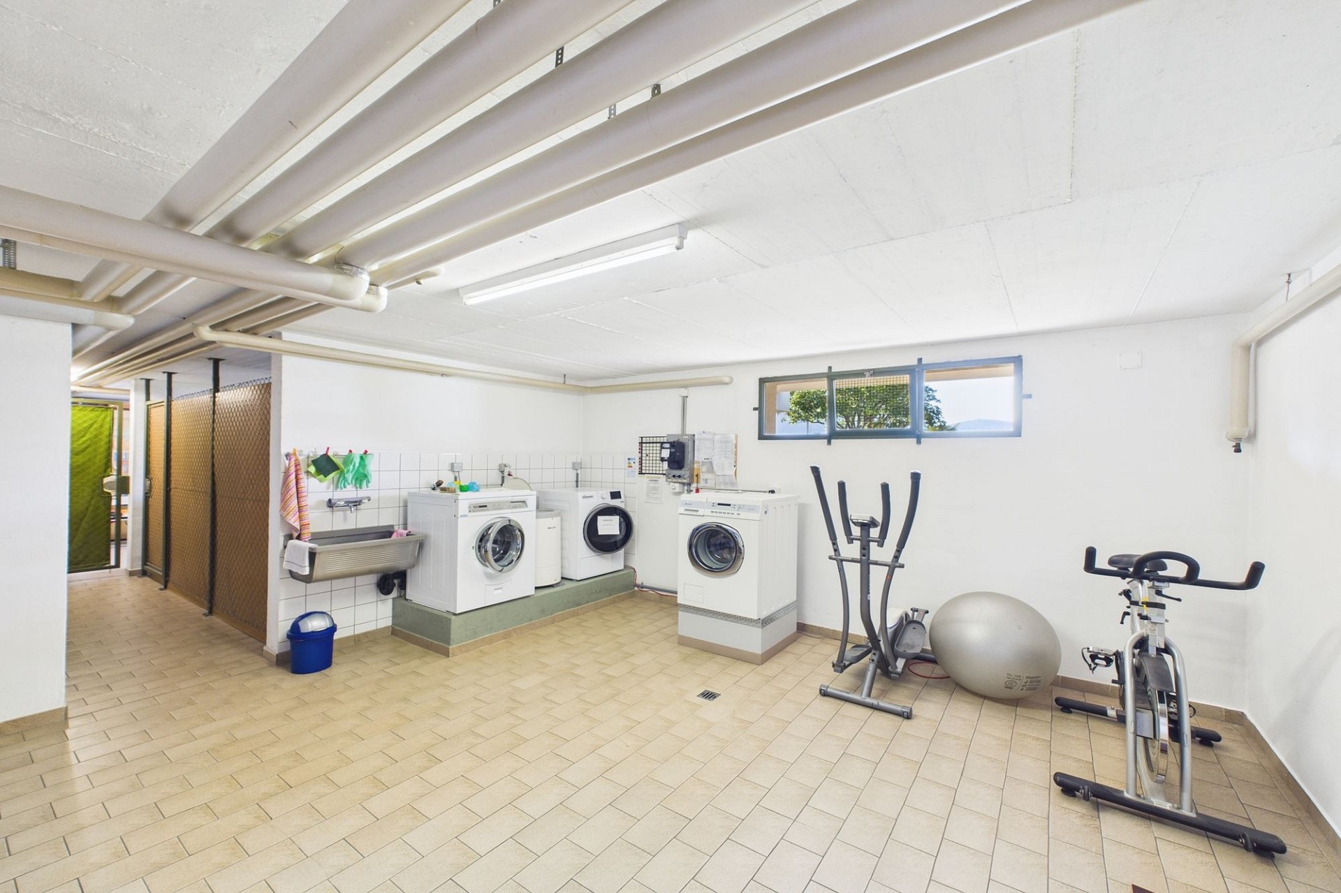 Hauswirtschaftsraum mit Waschmaschinen und Heimtrainer