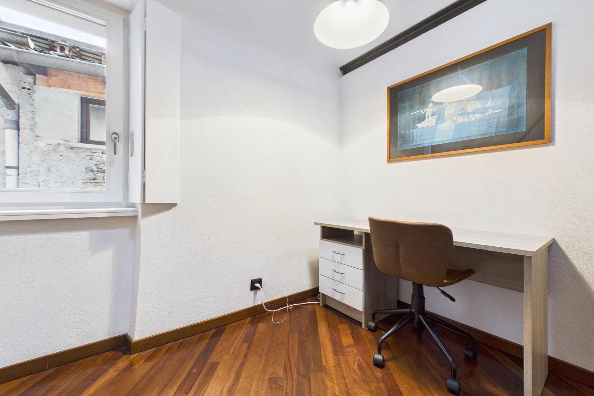 Kleines Arbeitszimmer mit Fenster und Schreibtisch