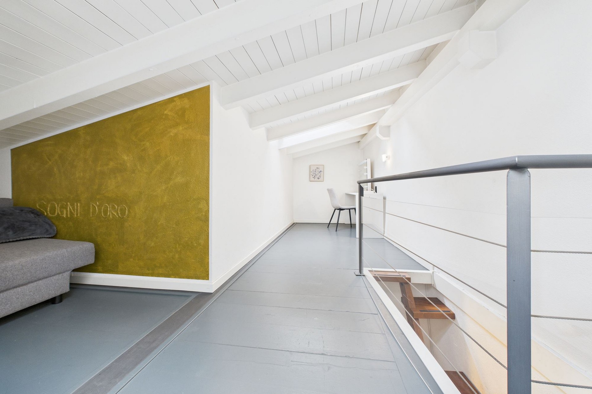 Galerie mit weißem Fachwerk und goldener Akzentwand