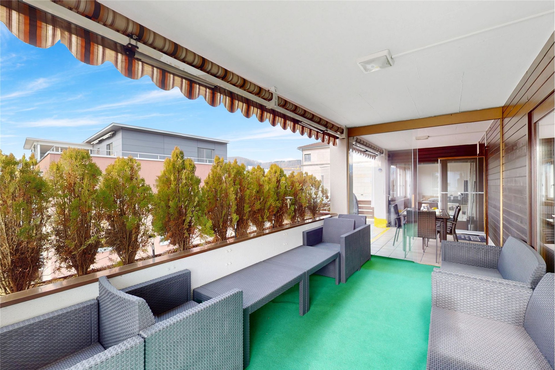 Überdachter Balkon mit Sitzgruppe