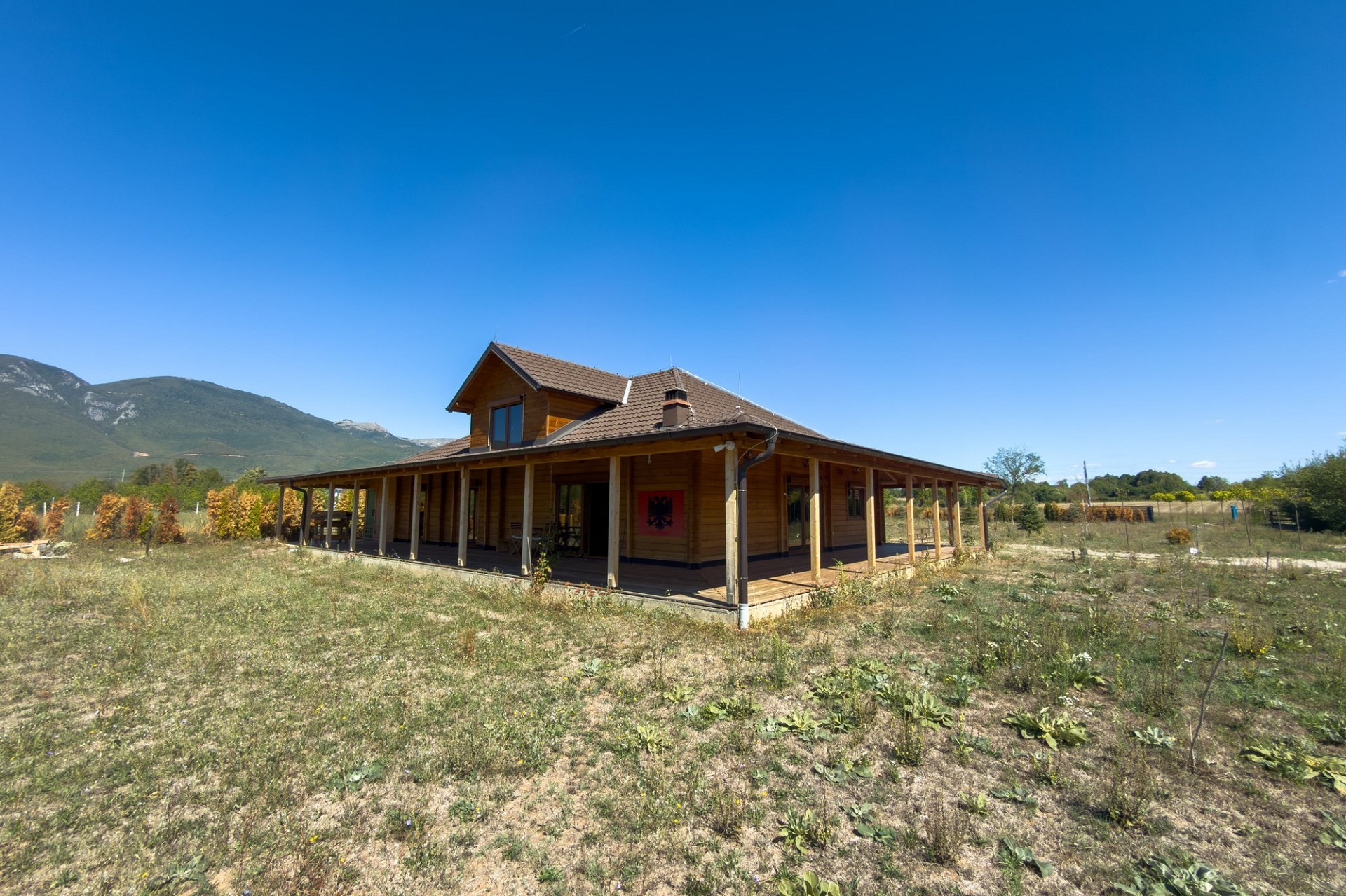 Holzhaus auf ländlichem Grundstück mit Bergkulisse