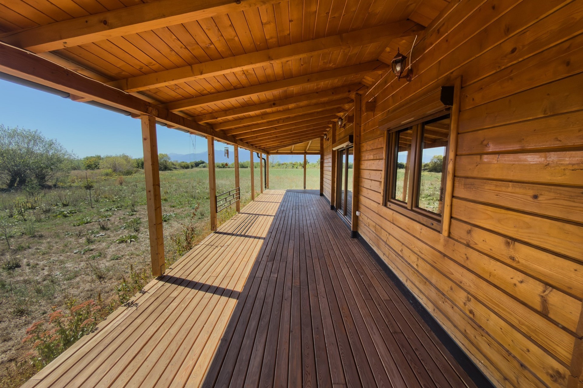 Überdachte Holzterrasse mit Blick ins Grüne