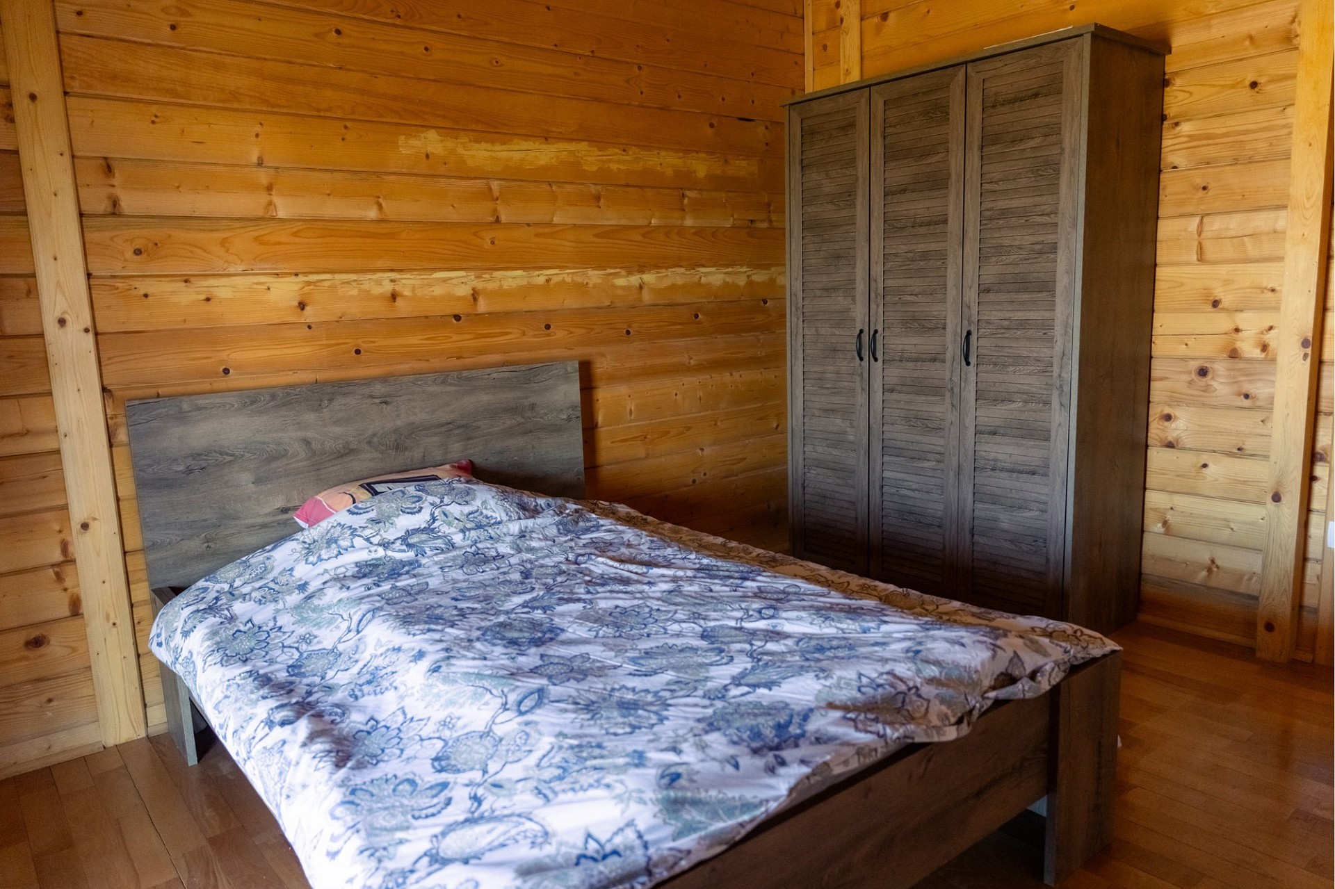 Holzvertäfeltes Schlafzimmer mit Bett und Kleiderschrank