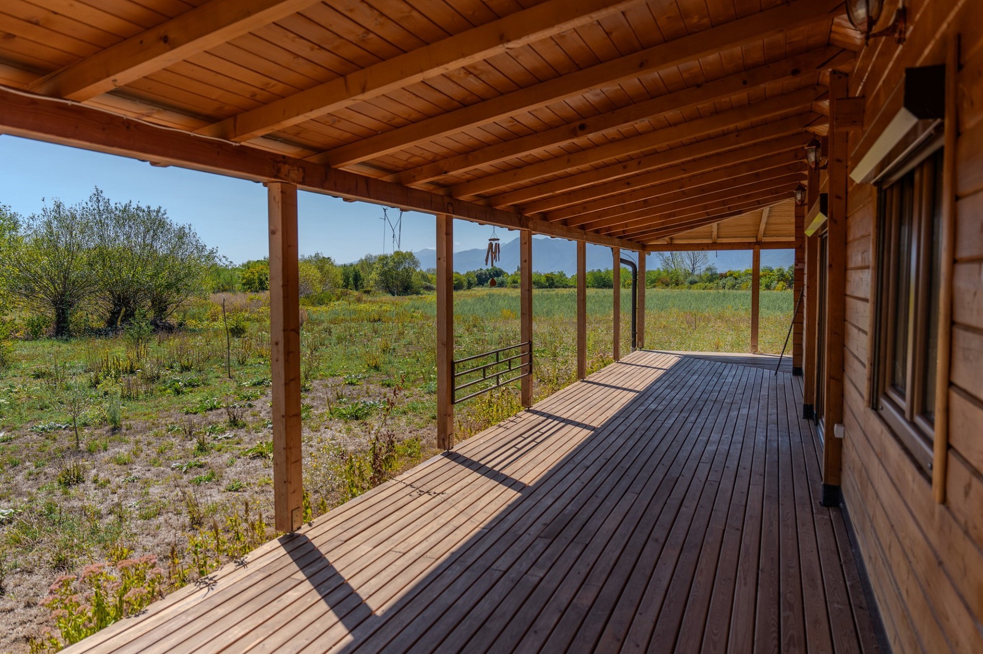 Überdachte Holzveranda mit Blick ins Grüne