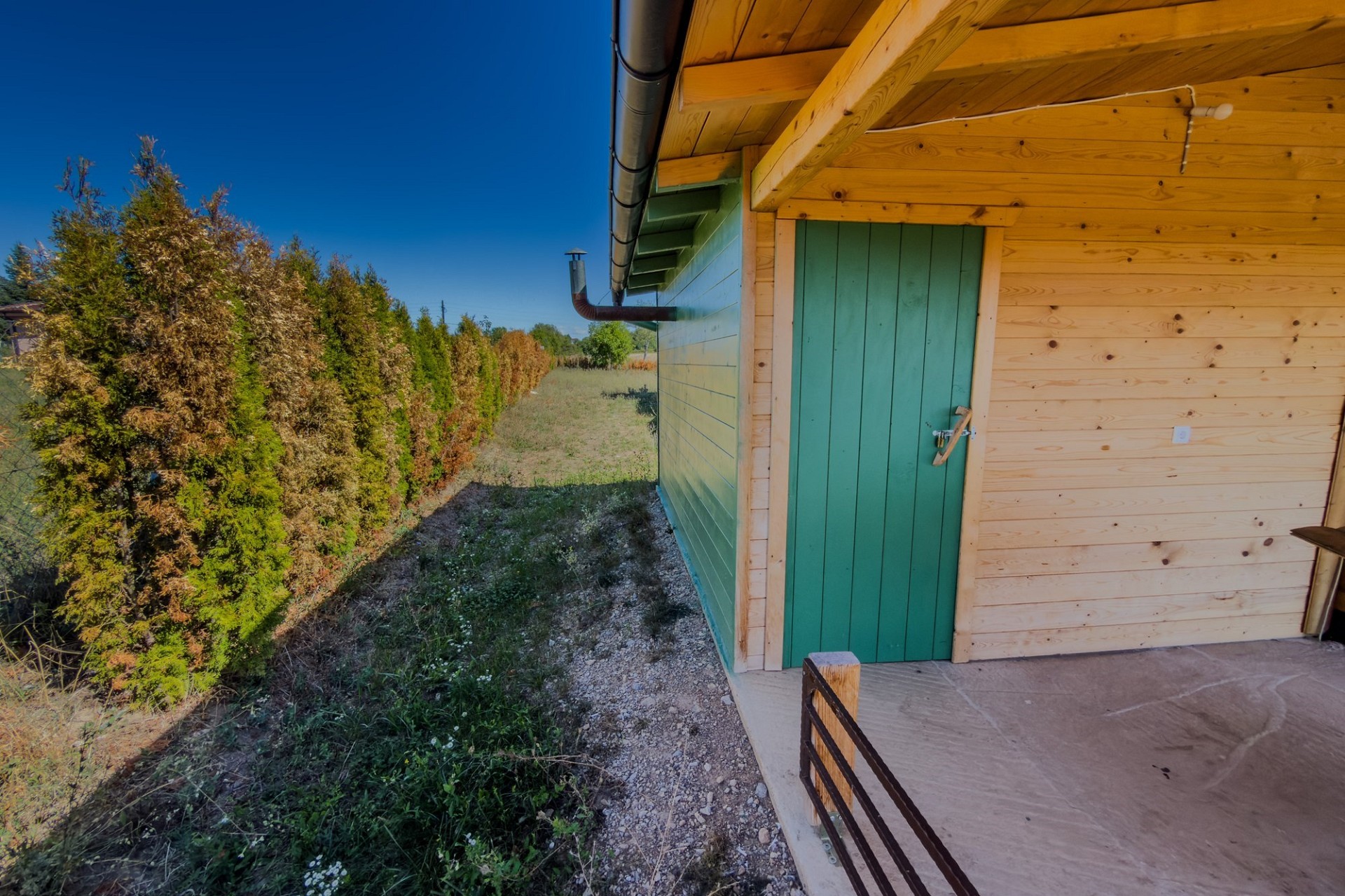 Außenansicht einer Holzfassade mit grüner Tür