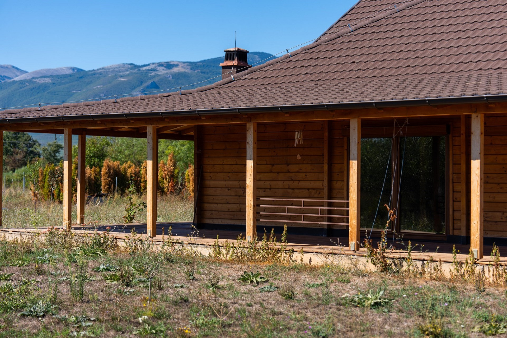 Holzhaus mit überdachter Veranda in ländlicher Berglage