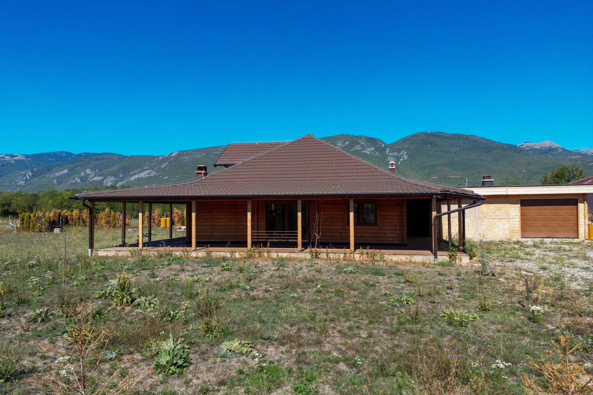 Ländliches Haus mit Walmdach und Bergkulisse