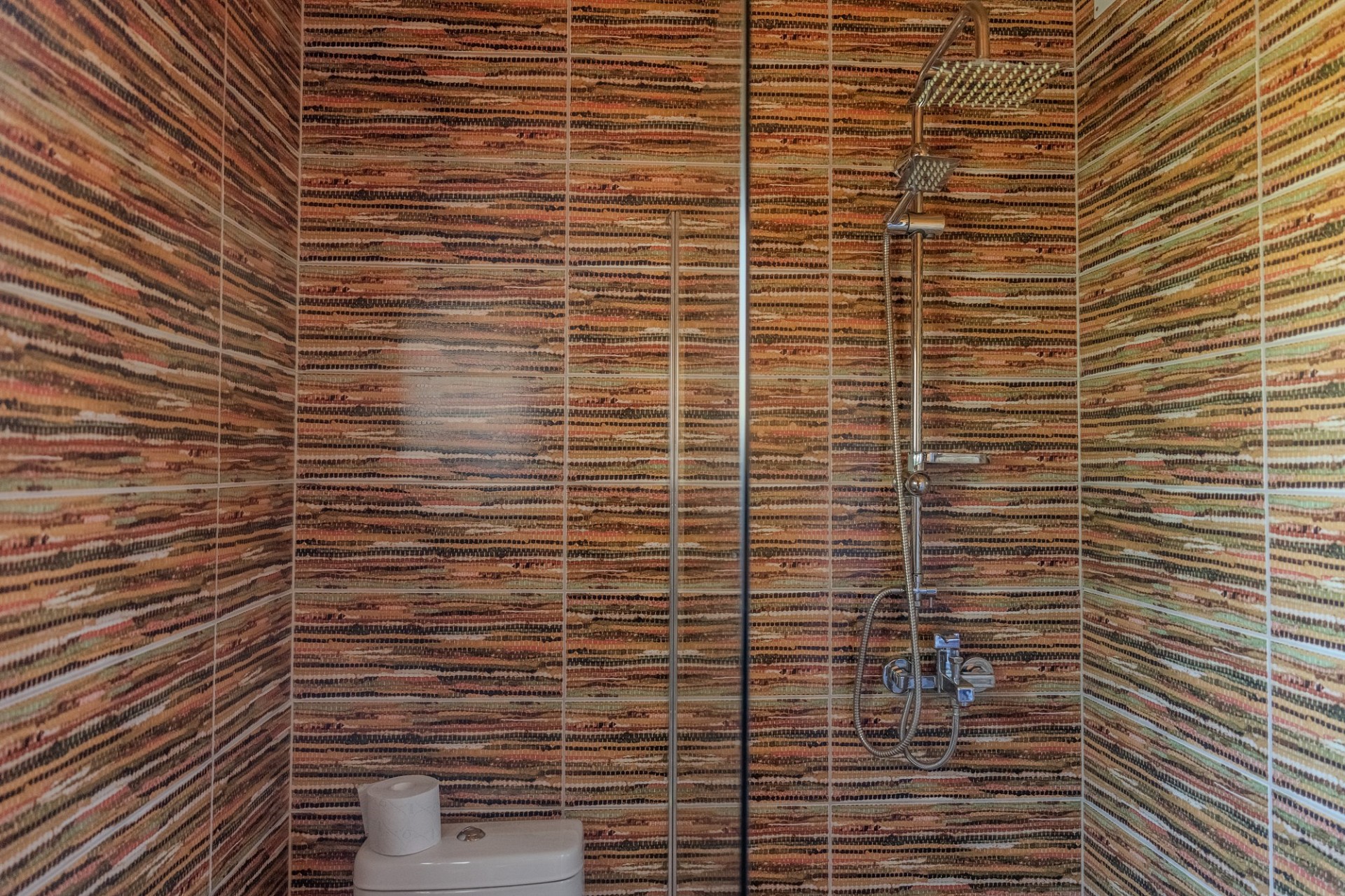 Bunt geflieste Dusche mit WC