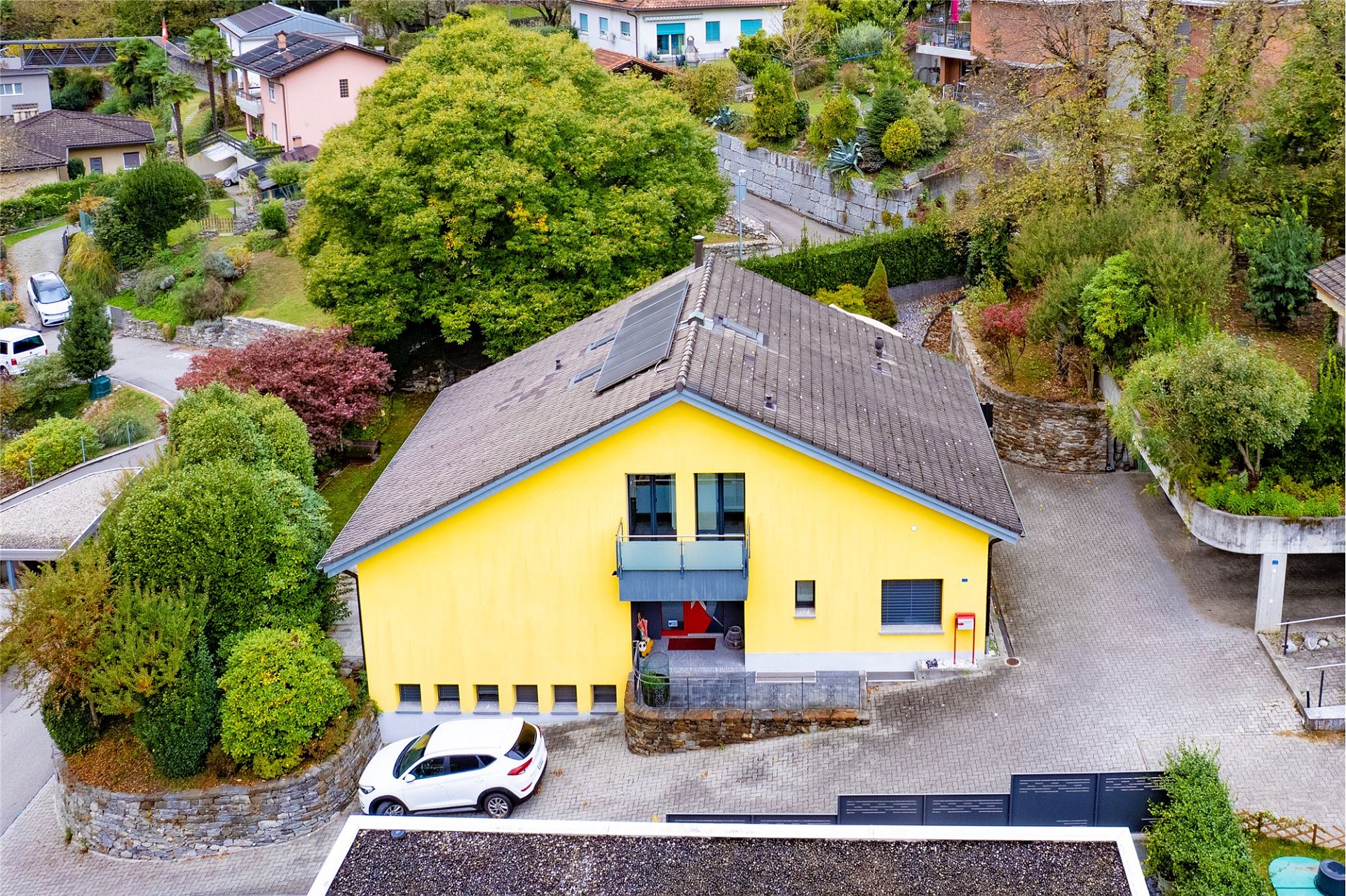 Gelbes Einfamilienhaus mit Satteldach in grüner Wohnlage