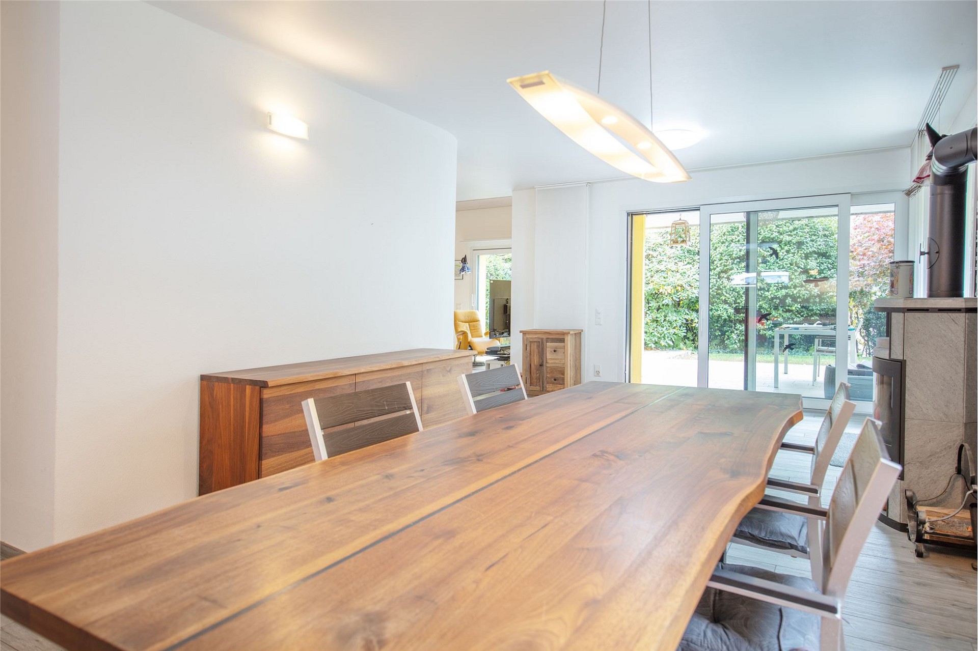 Heller Essbereich mit Holztisch und Zugang zum Garten