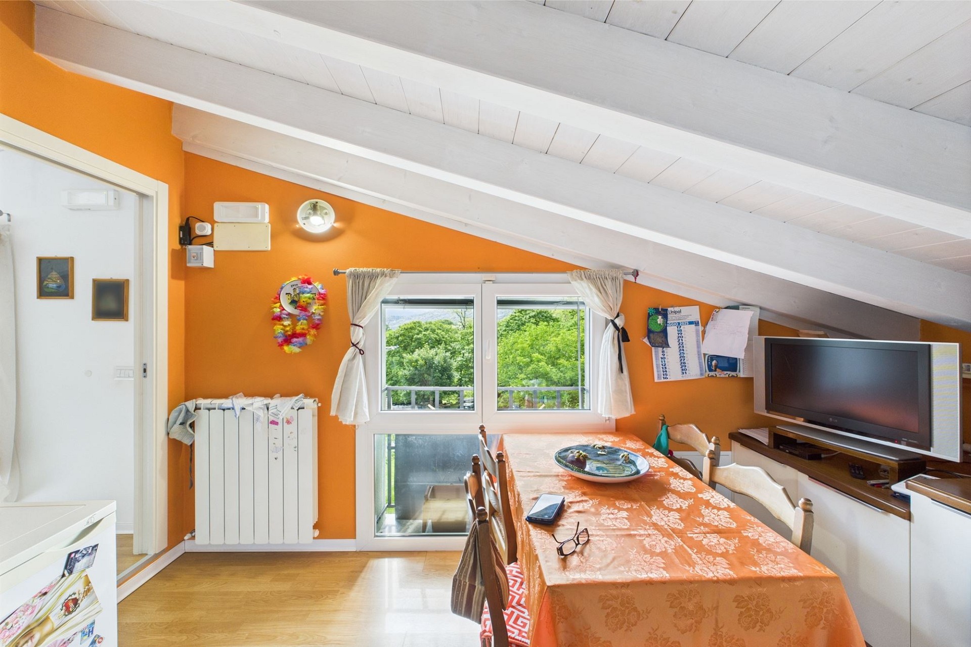 Dachgeschoss-Essbereich mit orangefarbener Wand