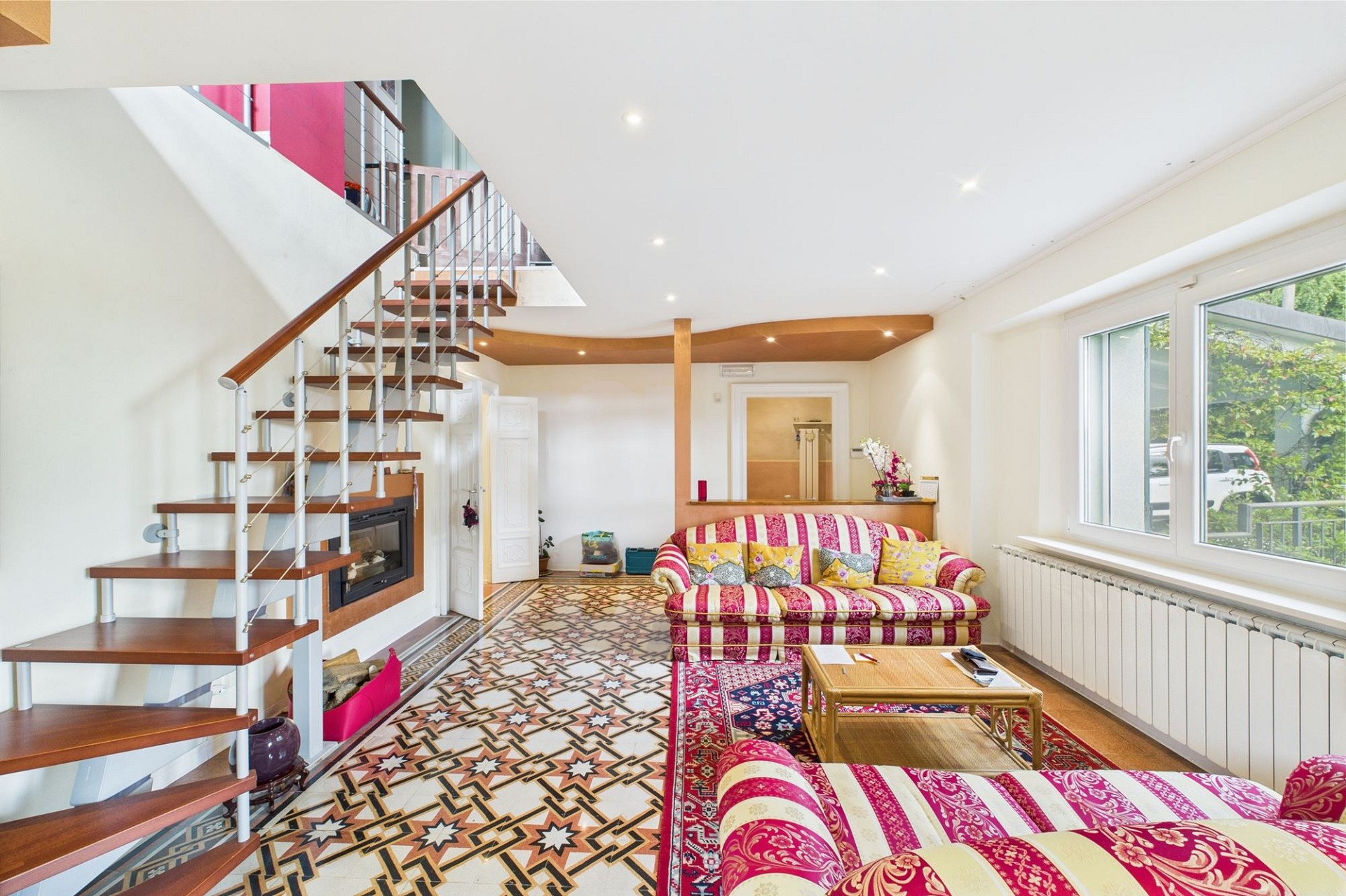 Heller Wohnraum mit Treppe und gemustertem Boden