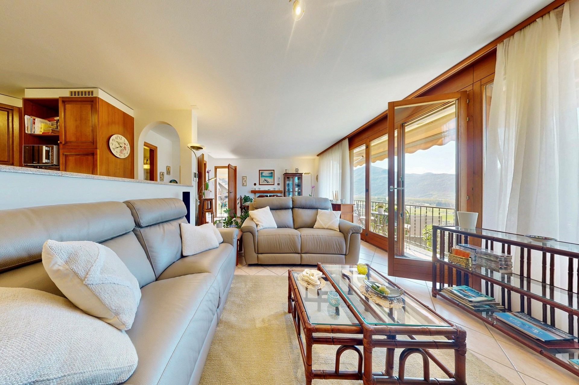 Helles Wohnzimmer mit Balkon- und Bergblick