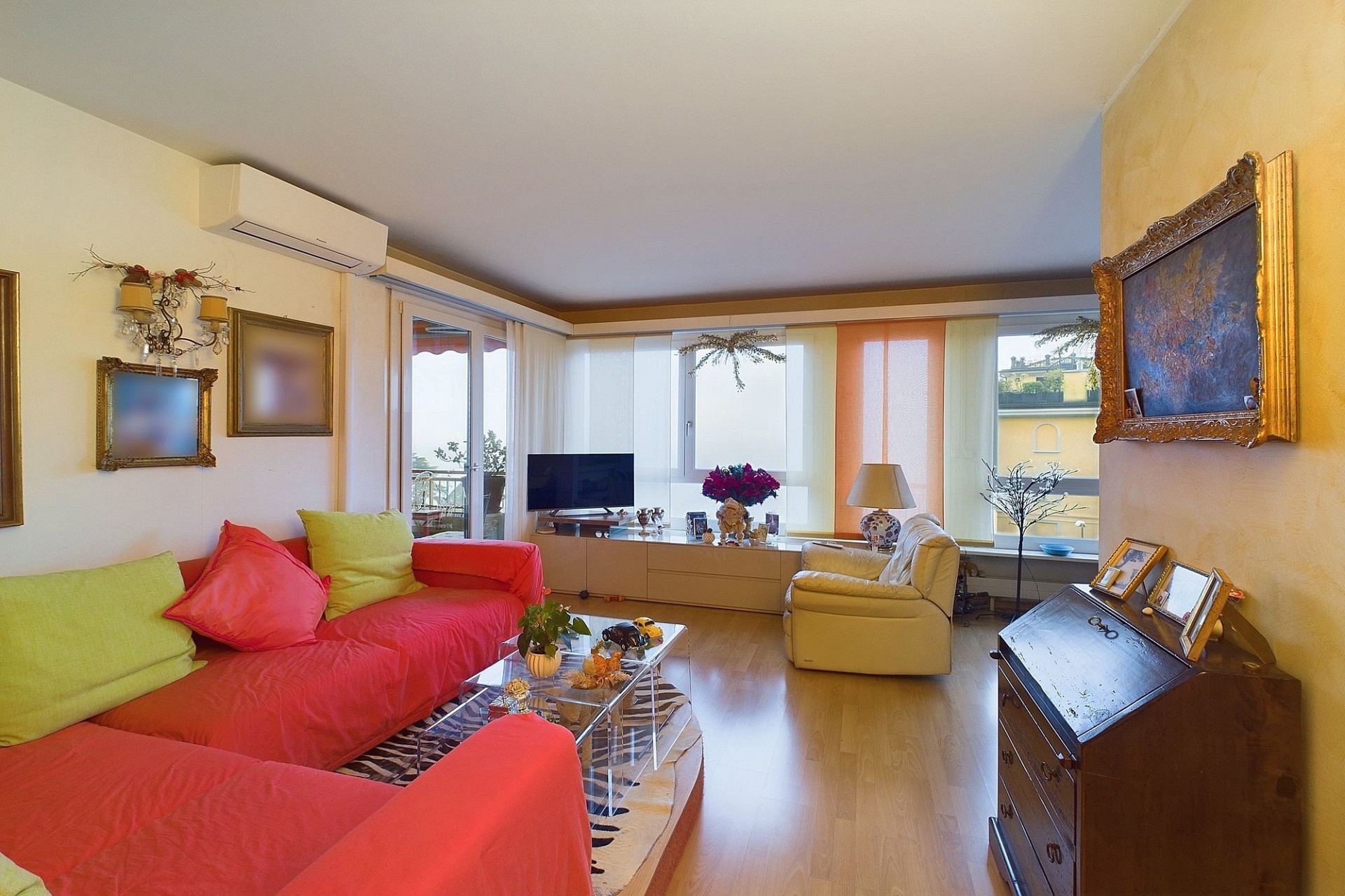 Bunt eingerichtetes Wohnzimmer mit Balkonblick