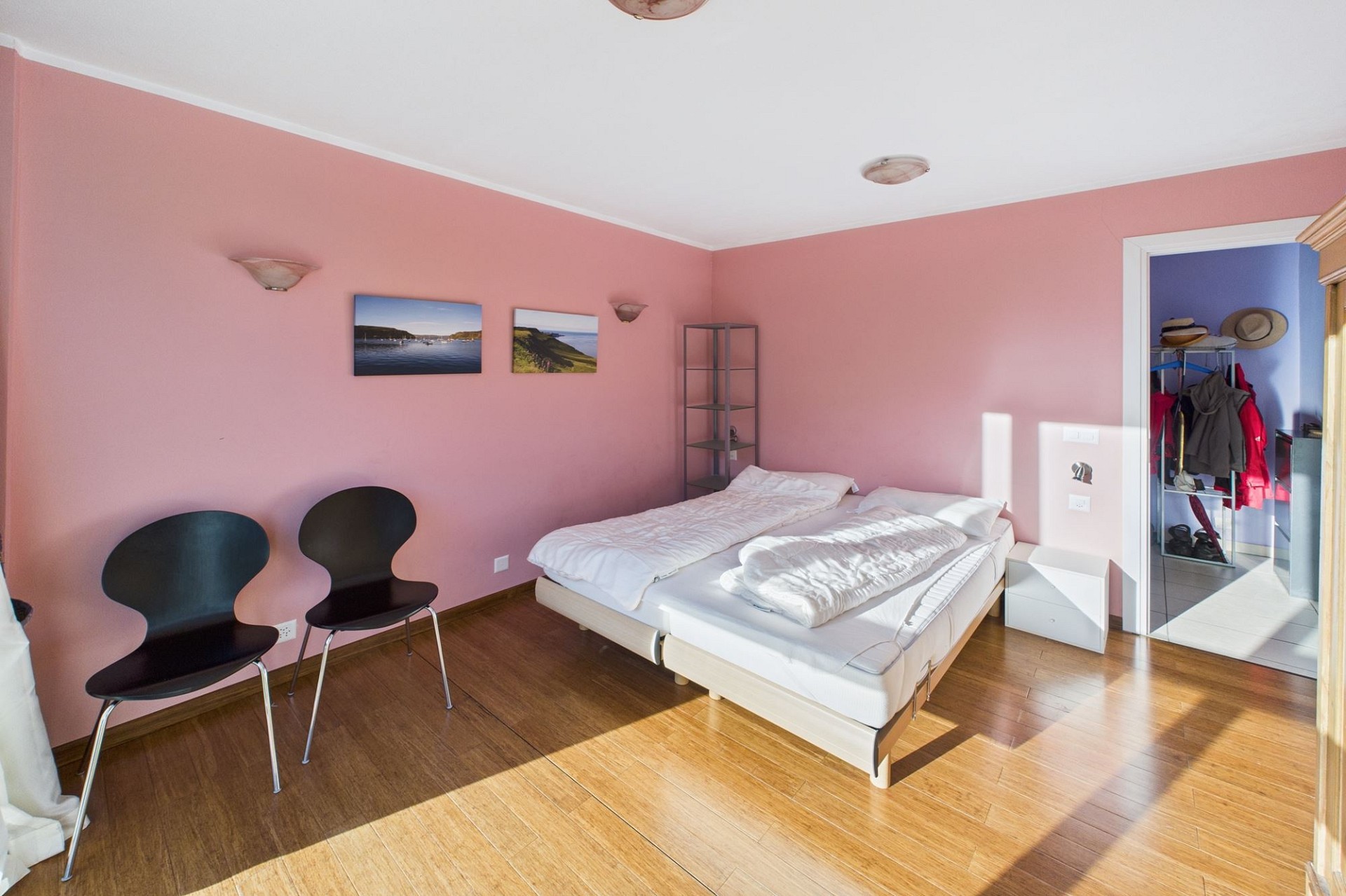 Schlafzimmer mit rosa Wänden und Holzfußboden