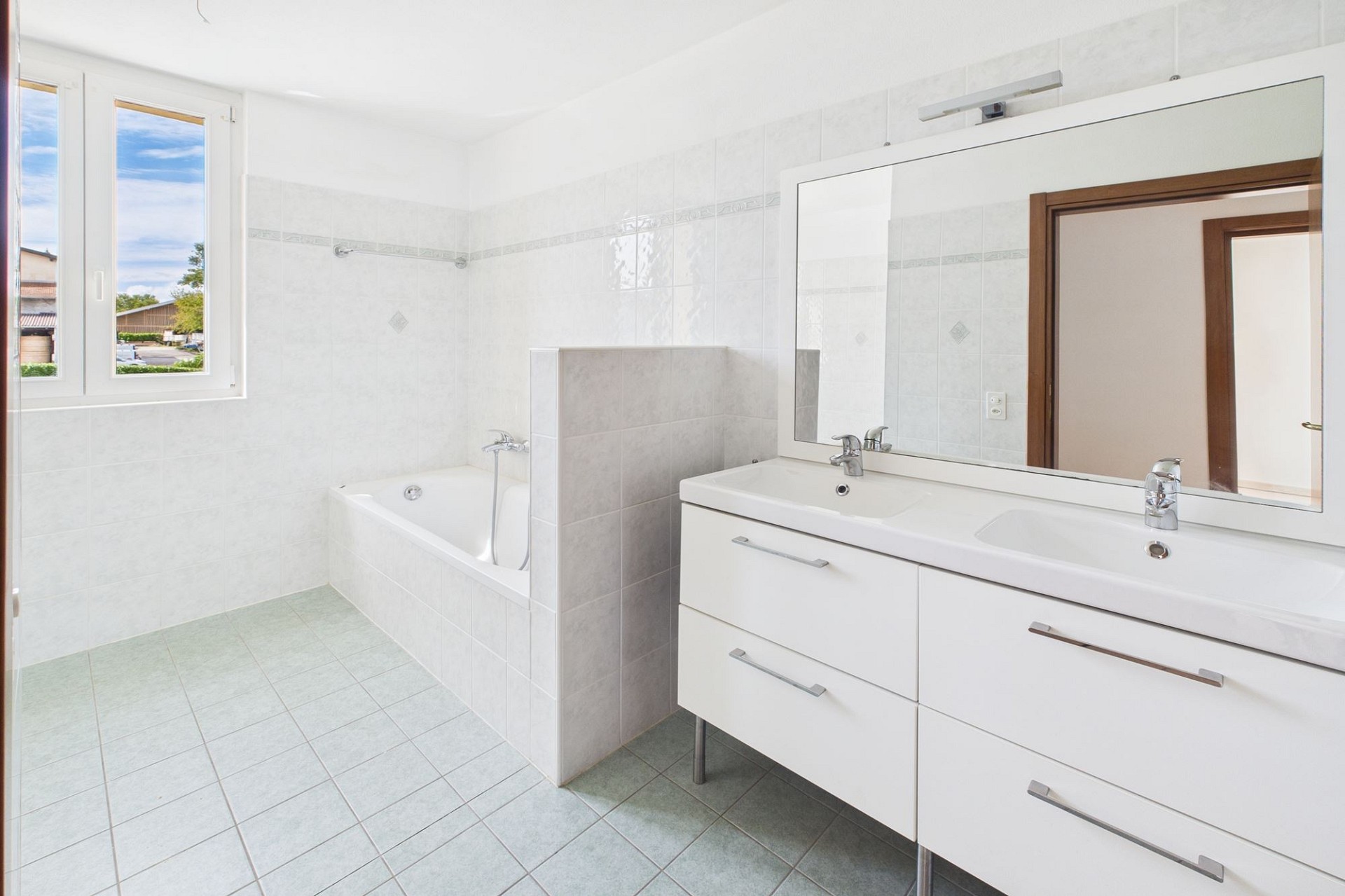 Helles Badezimmer mit Doppelwaschtisch und Badewanne