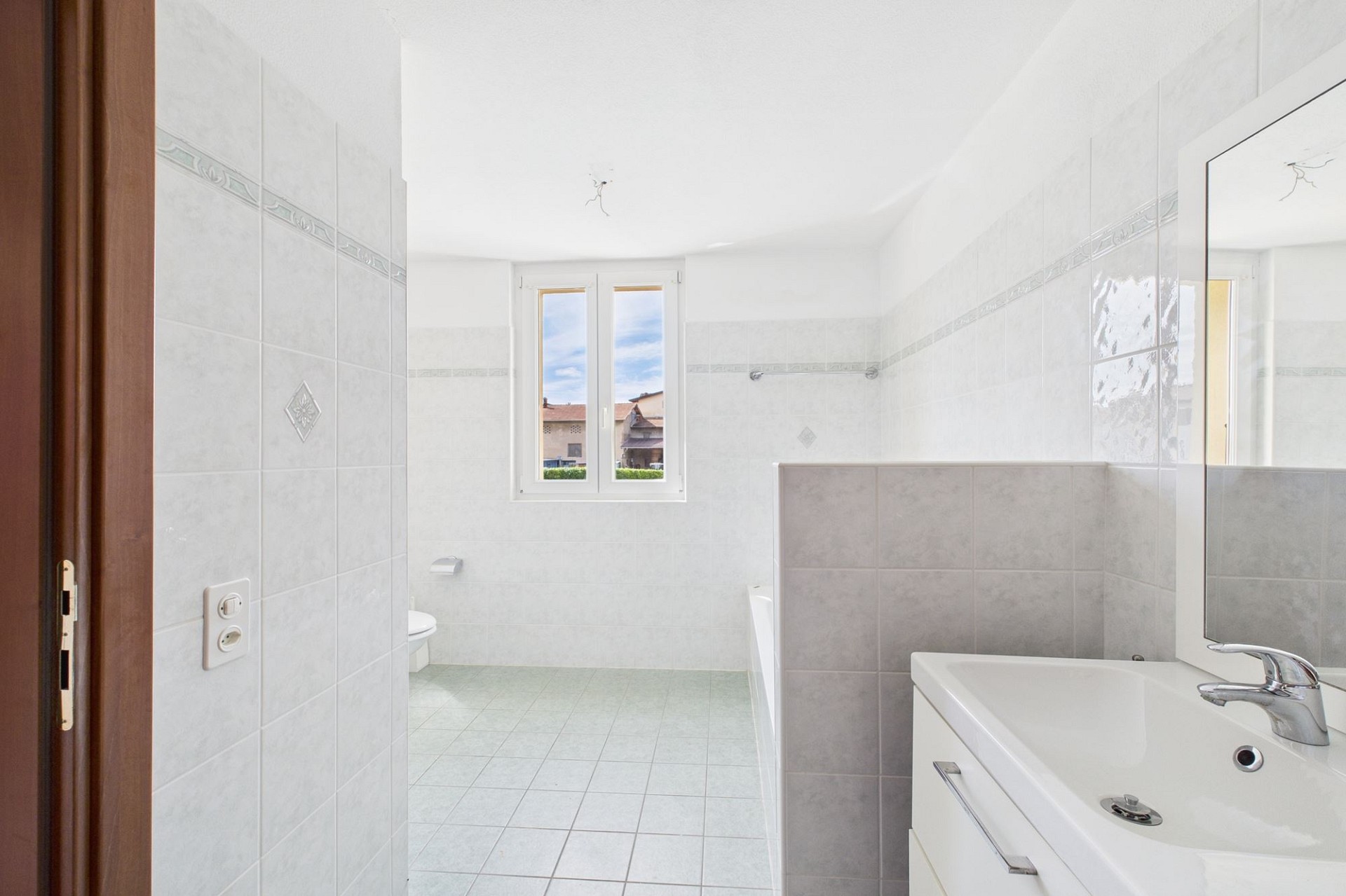 Helles Badezimmer mit Fenster und Waschbecken