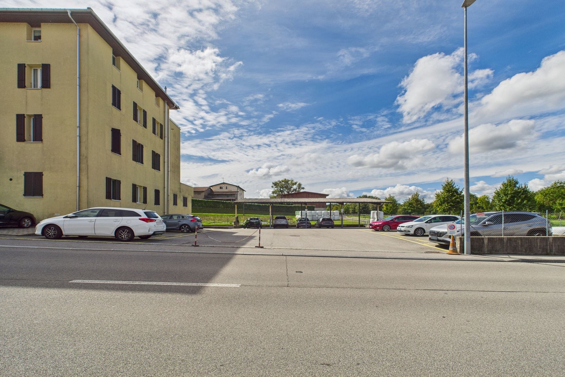 Außenansicht eines Mehrfamilienhauses mit Parkplatz