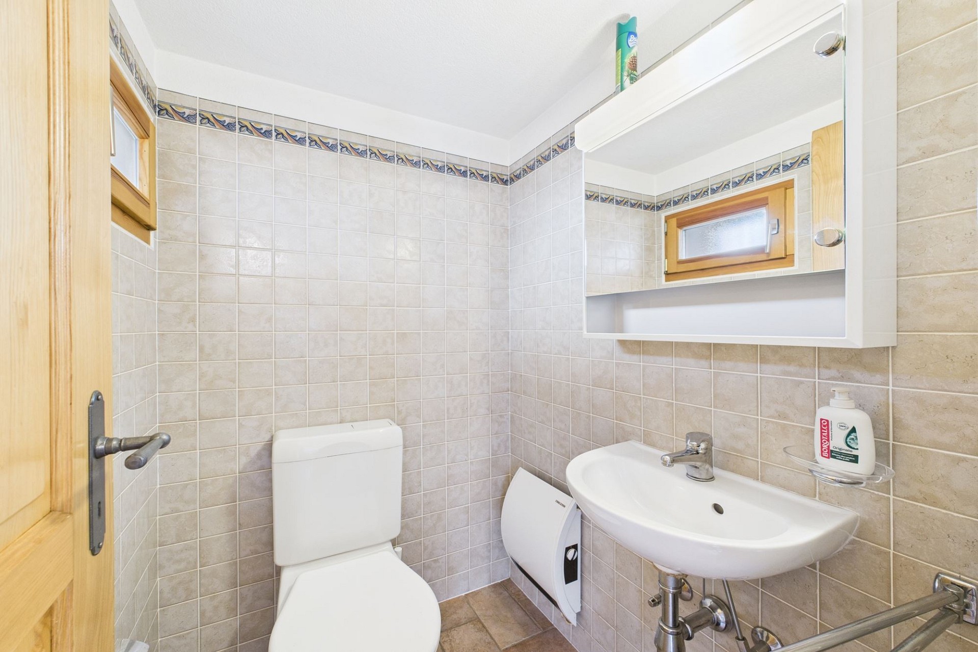 Gäste-WC mit Fliesen und Holzdetails