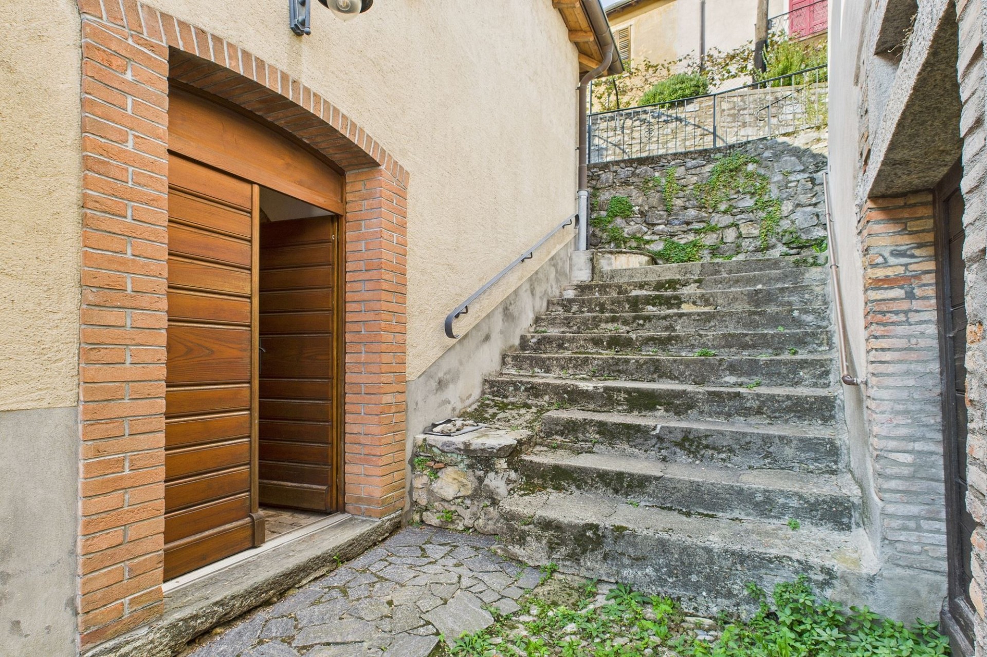Außenzugang mit Steintreppe und Holztür