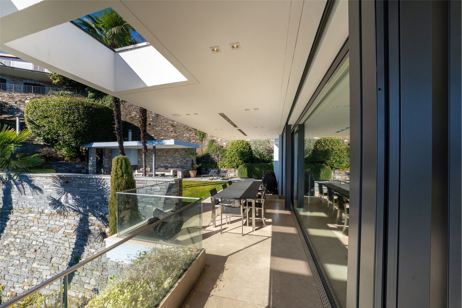 Überdachte Dachterrasse mit Gartenblick