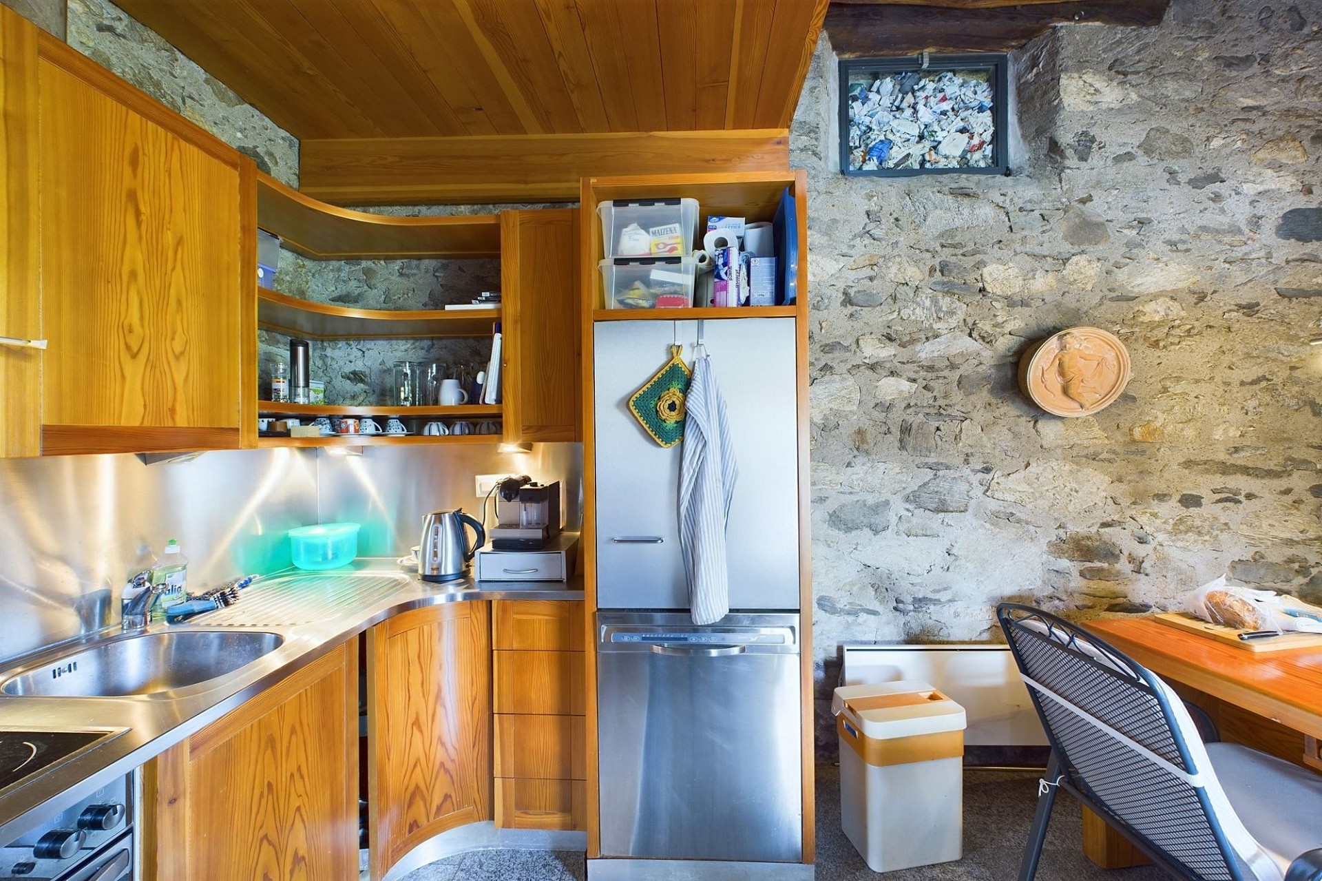Rustikale Küche mit Steinwand und Holzfronten
