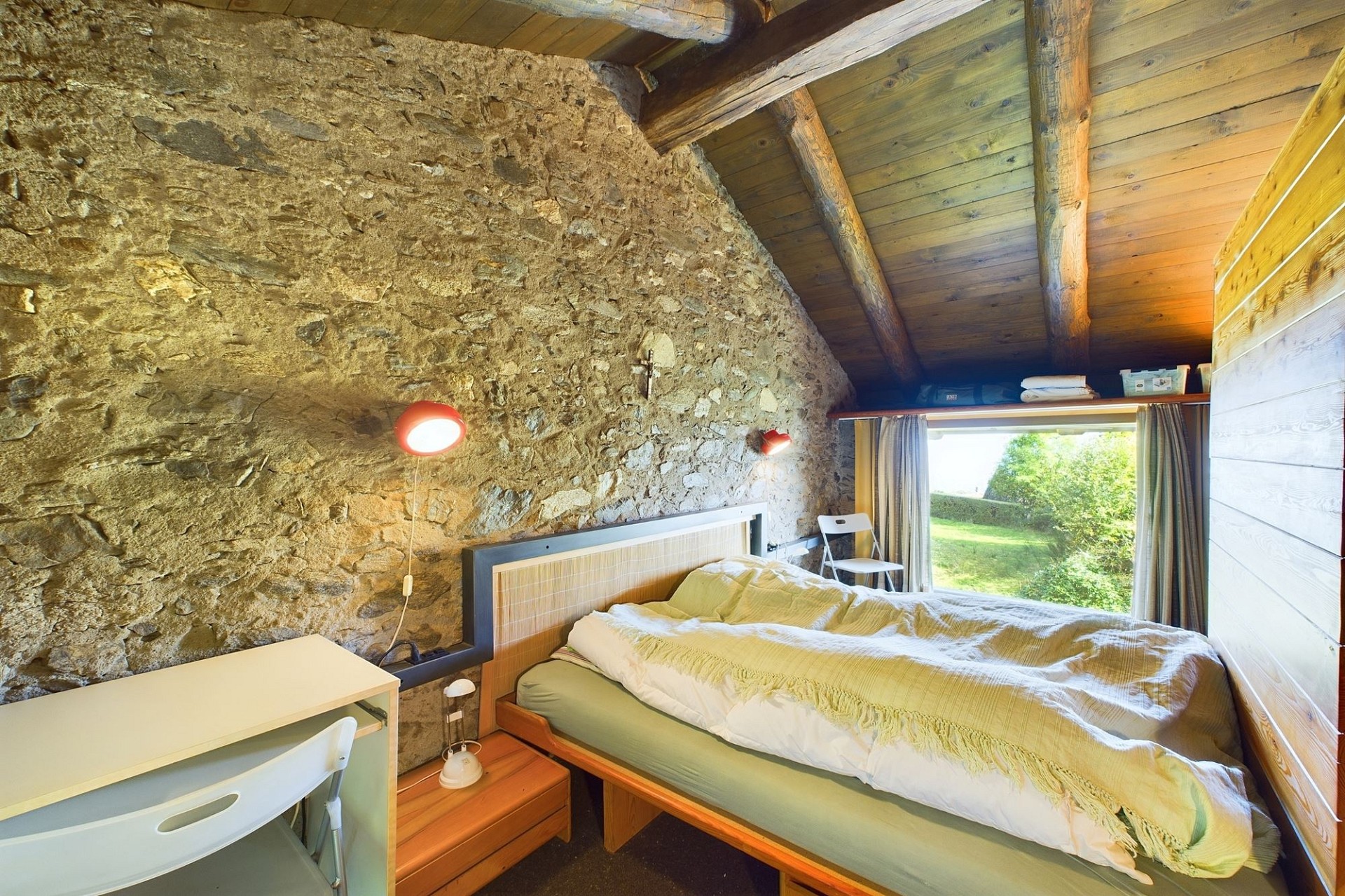 Gemütliches Schlafzimmer im Dachgeschoss mit Natursteinwand