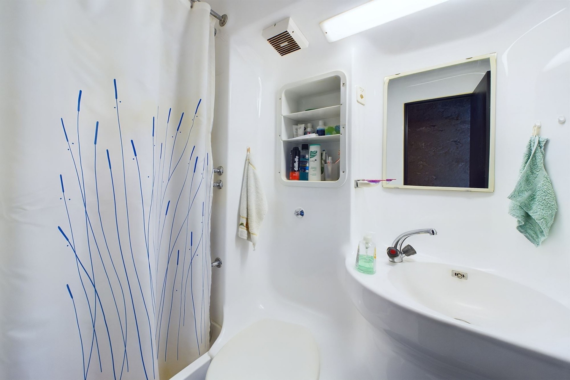 Kleines helles Badezimmer mit Dusche und Waschbecken