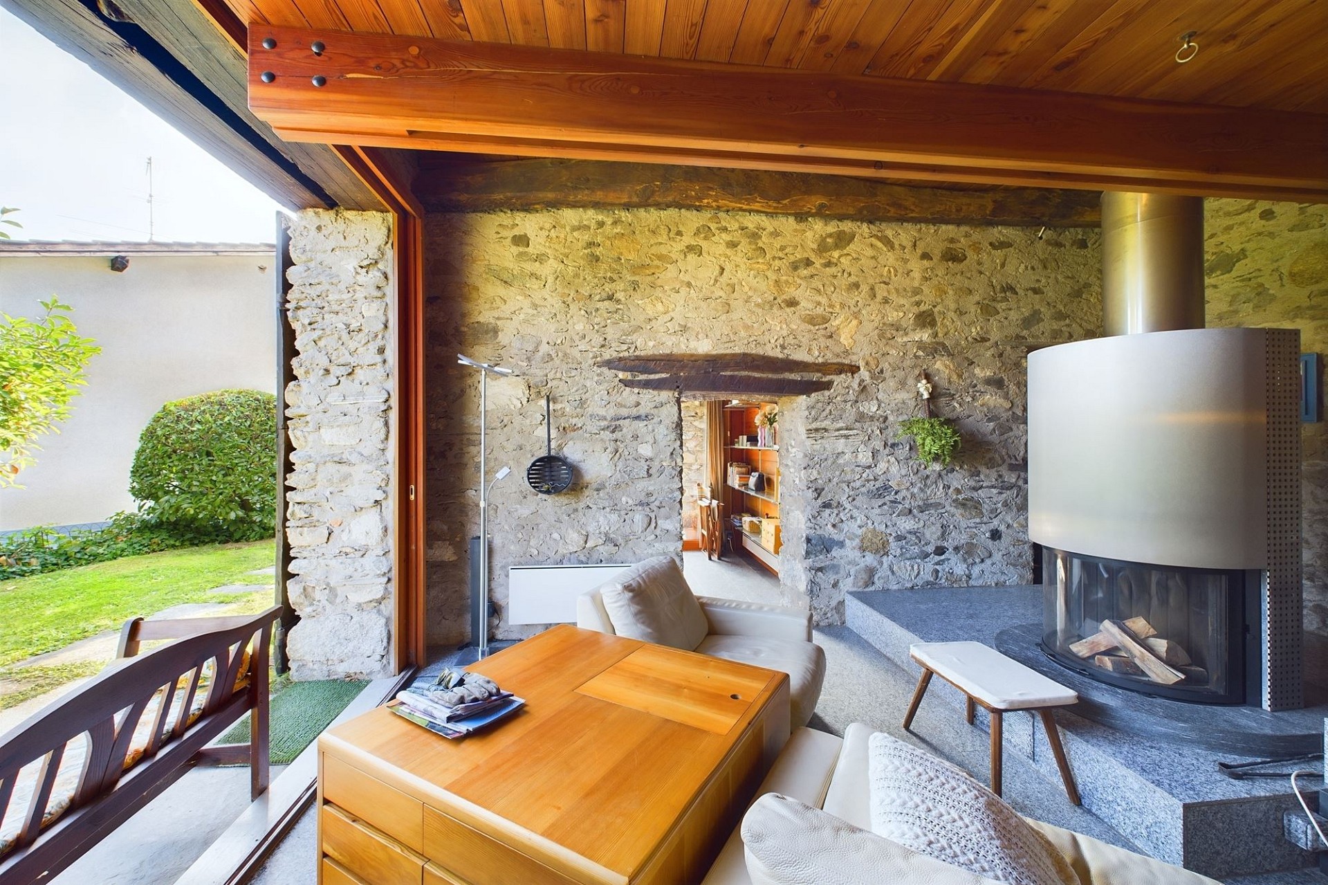 Gemütlicher Wohnraum mit Natursteinwand und Kamin