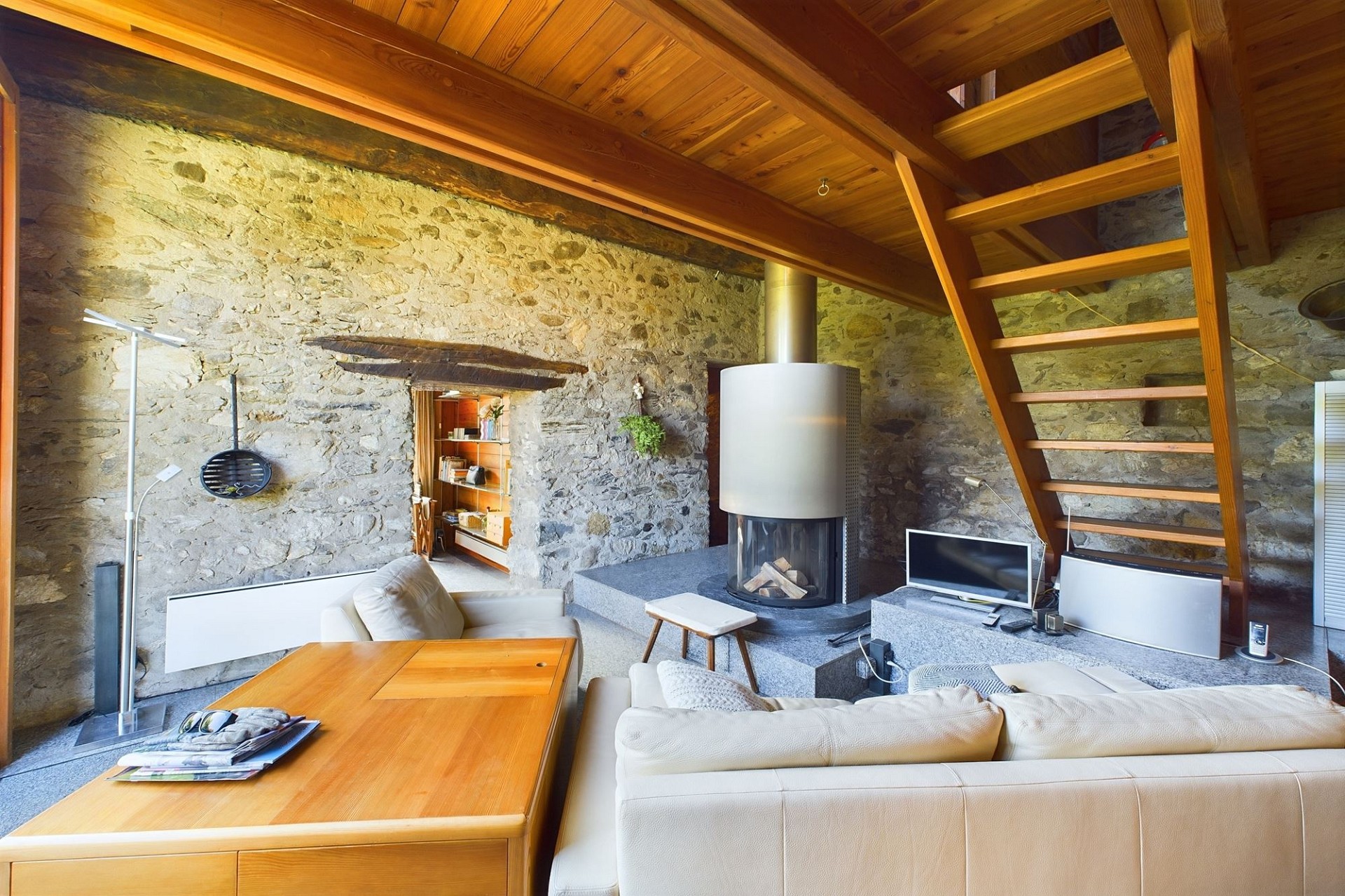 Wohnzimmer mit Kamin und Holztreppe