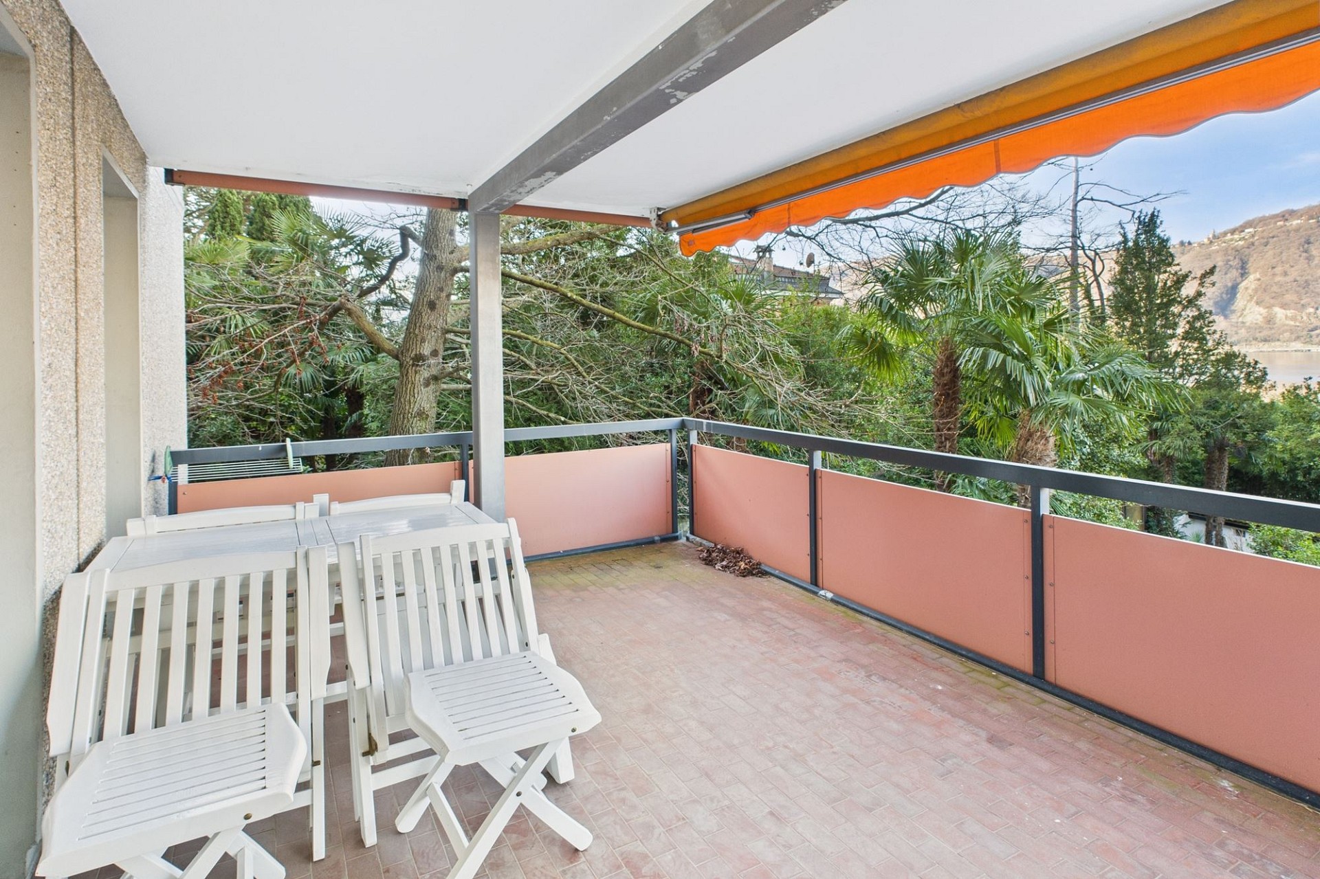 Überdachter Balkon mit Sitzgruppe und Ausblick ins Grüne