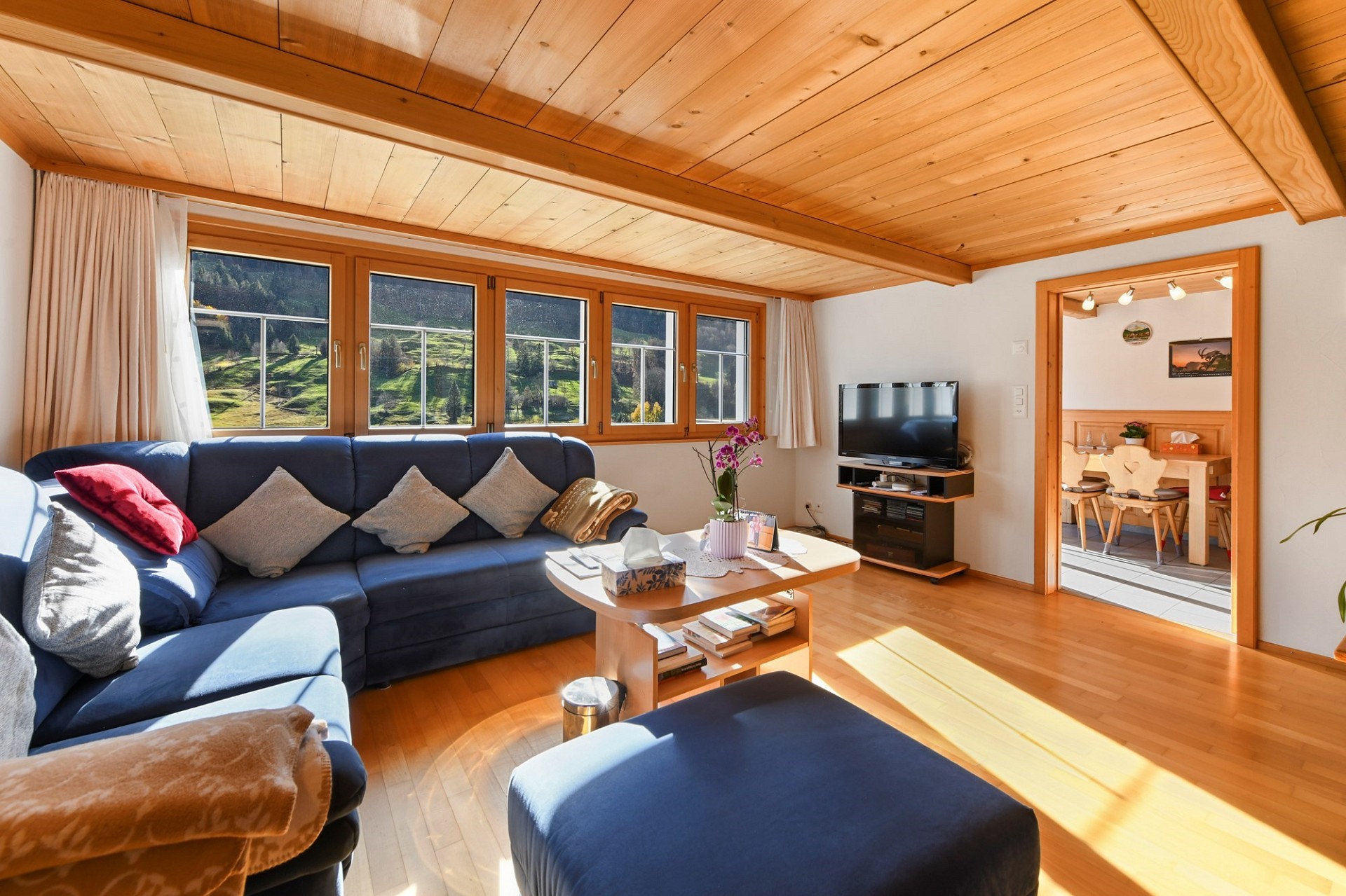 Helles Wohnzimmer mit Holzausbau und Bergblick